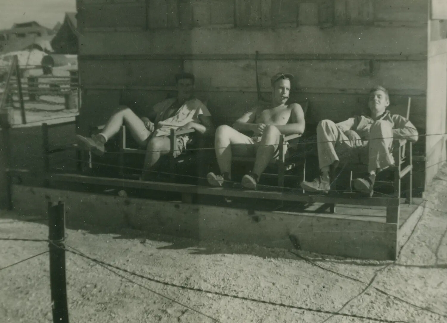 Three Servicemen Relaxing in Deck Chairs Outside Barracks Building, WWII Personal Photo Album