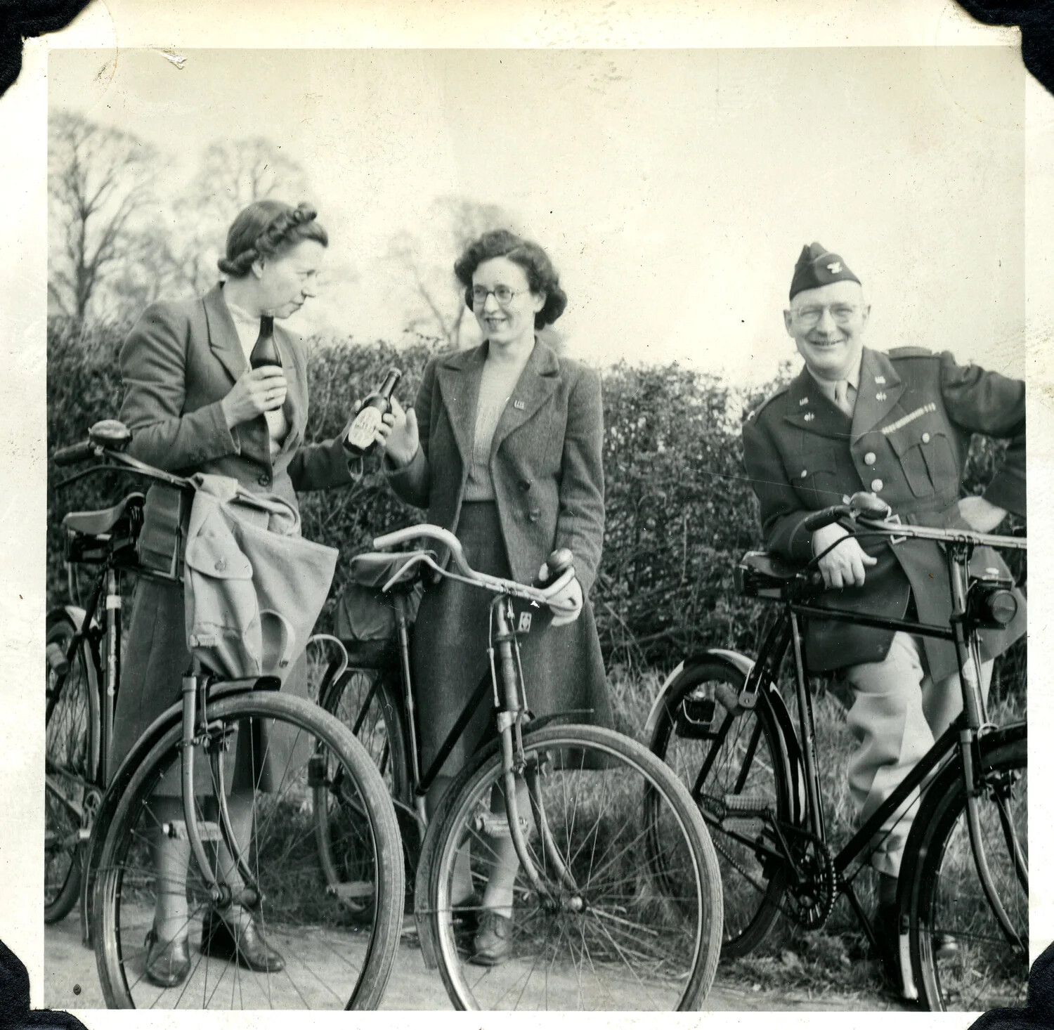 American Serviceman and Two Women with Bicycles Along a Country Hedgerow, WWII England