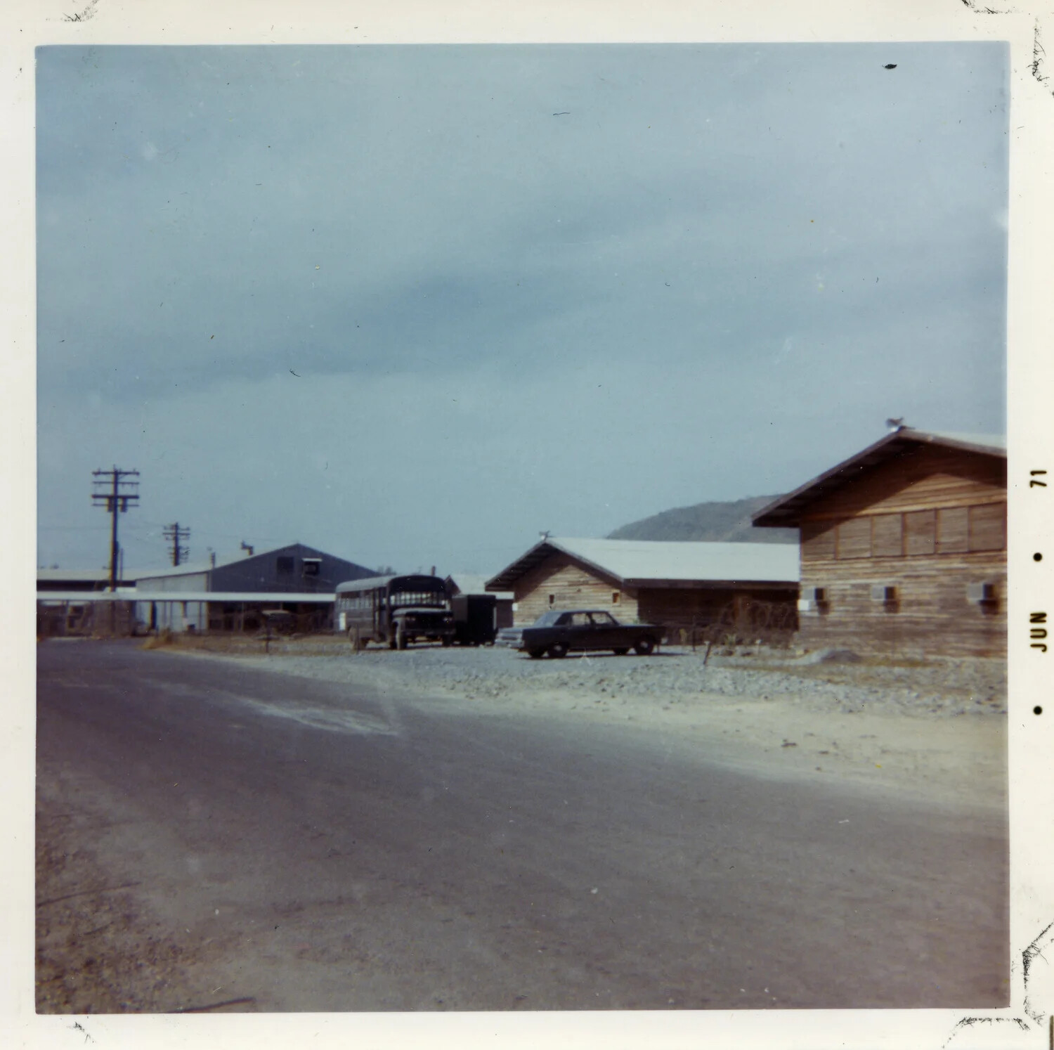 Base Camp Street with Bus and Parked Sedan, Vietnam, 1971