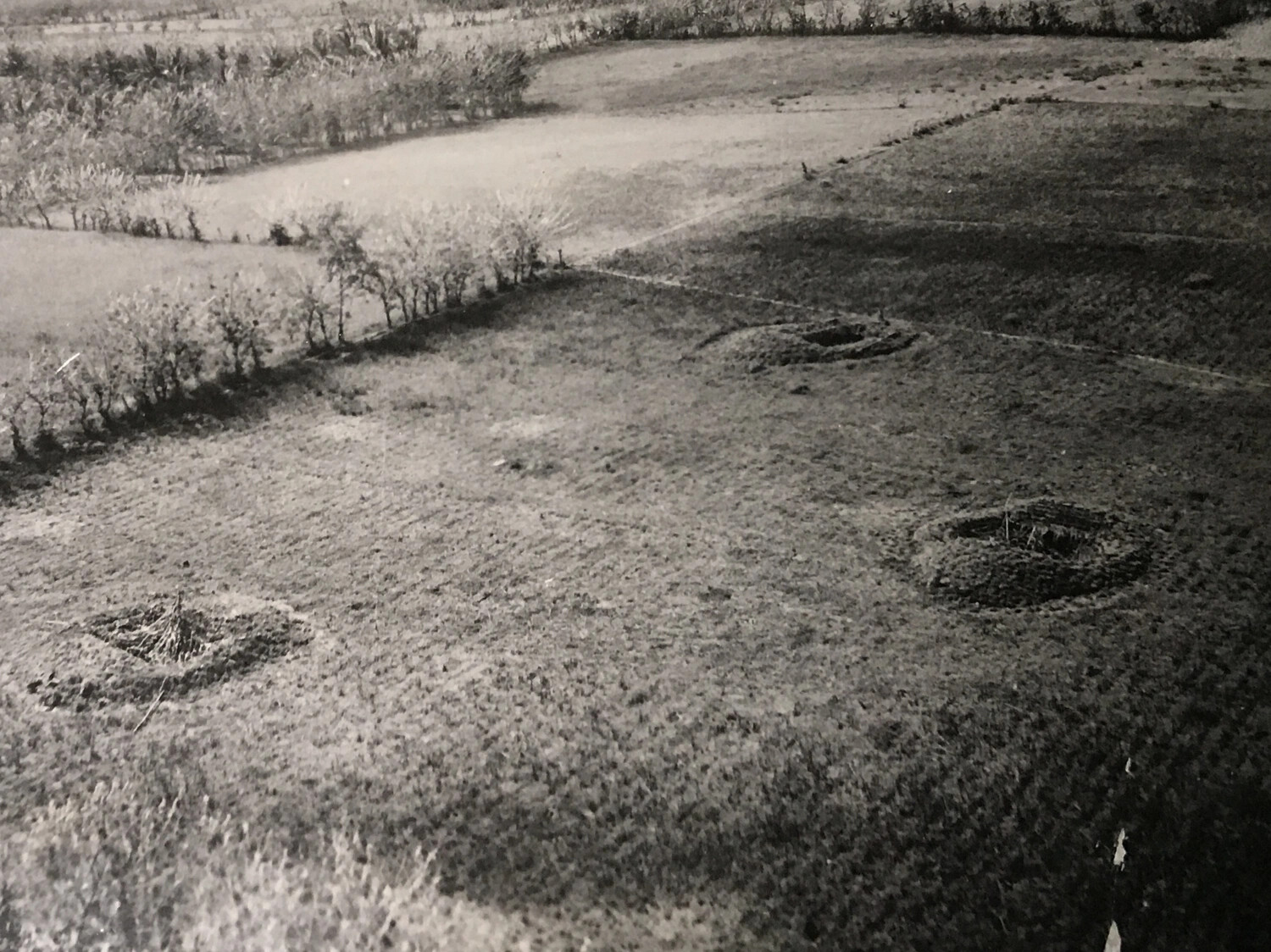 Close Aerial View of Small Craters or Camouflaged Pits in Cultivated Field