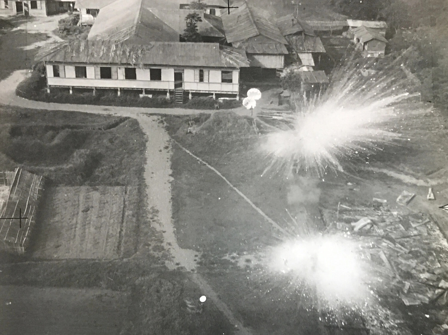312th Bomb Group Strike Photograph — Bomb Detonations Near Village Building, Luzon, Philippines