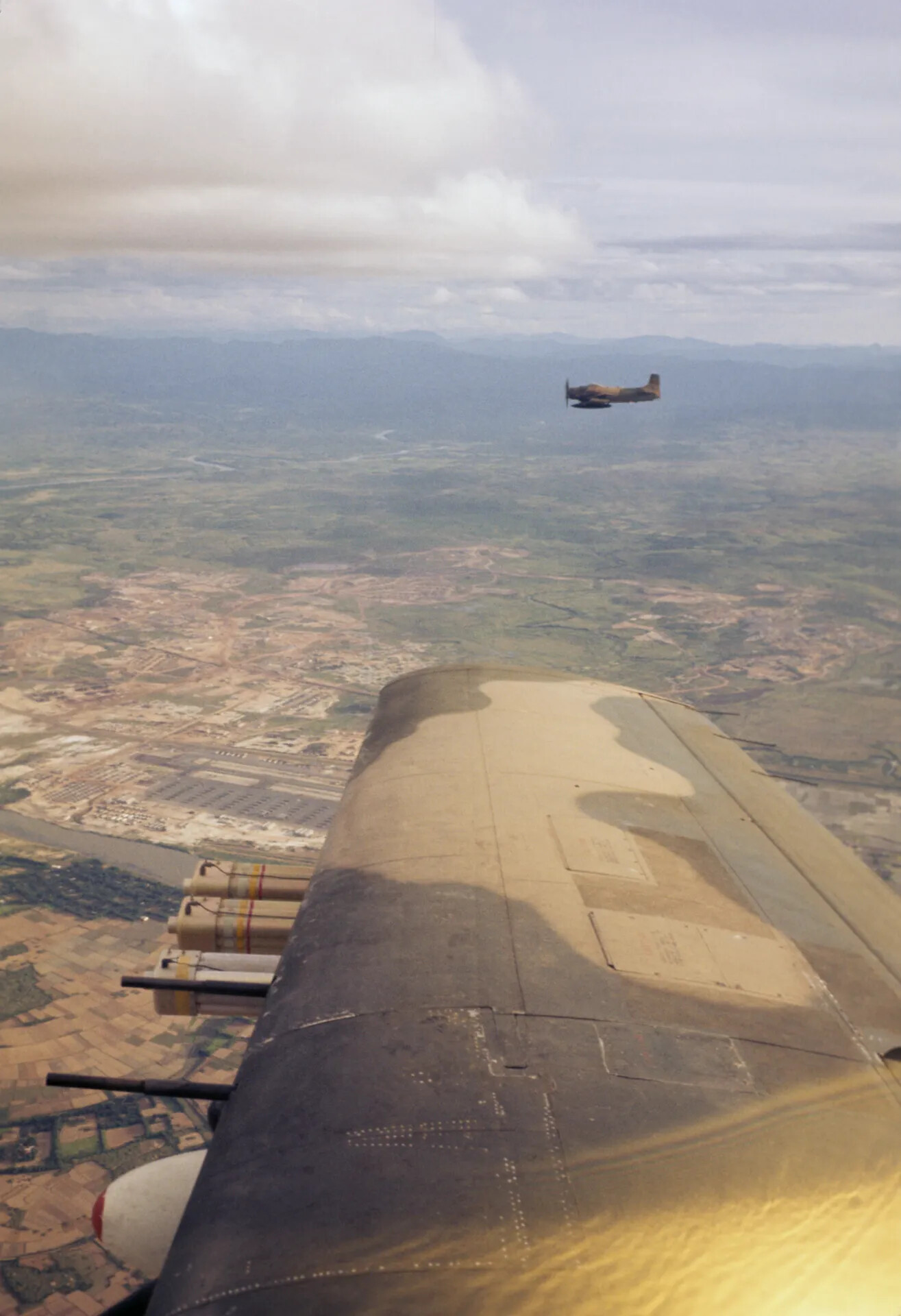 Air-to-Air View of Formation Flying A-1 Skyraider Over Vietnam Airfield