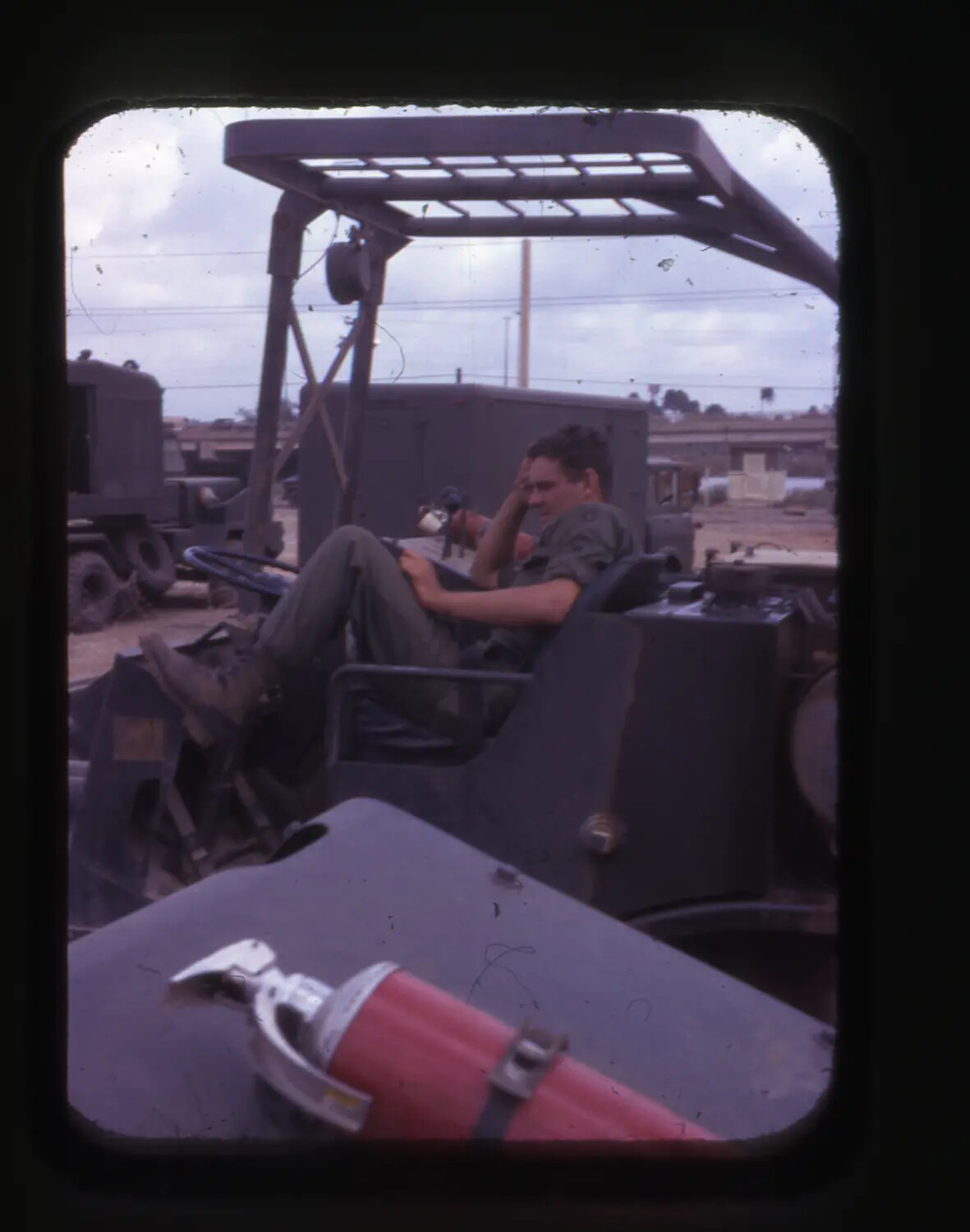U.S. Soldier Resting on Forklift at Supply Depot, Cam Ranh Bay, Vietnam War