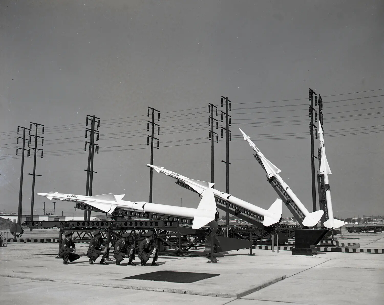 Nike Missile Battery with Four Erected Missiles and Army Personnel in Formation