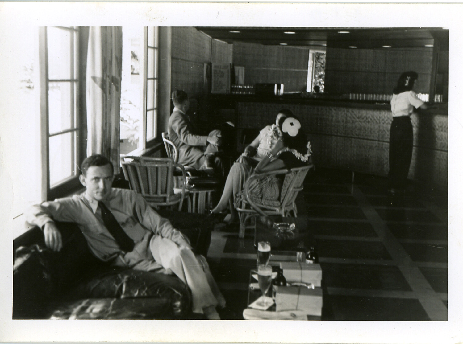 Servicemen and Guests in Hotel Lounge with Hibiscus-Adorned Woman, Hawaii, WWII Era