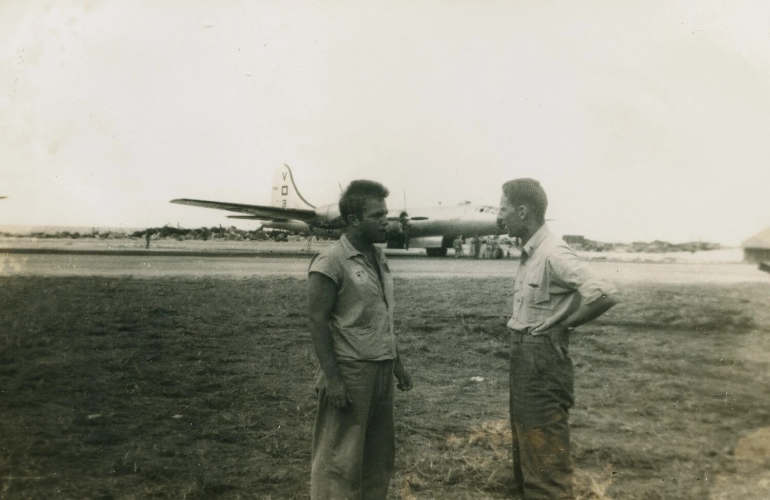 Two Airmen Conversing on Airfield Apron with B-17 Flying Fortress in Background