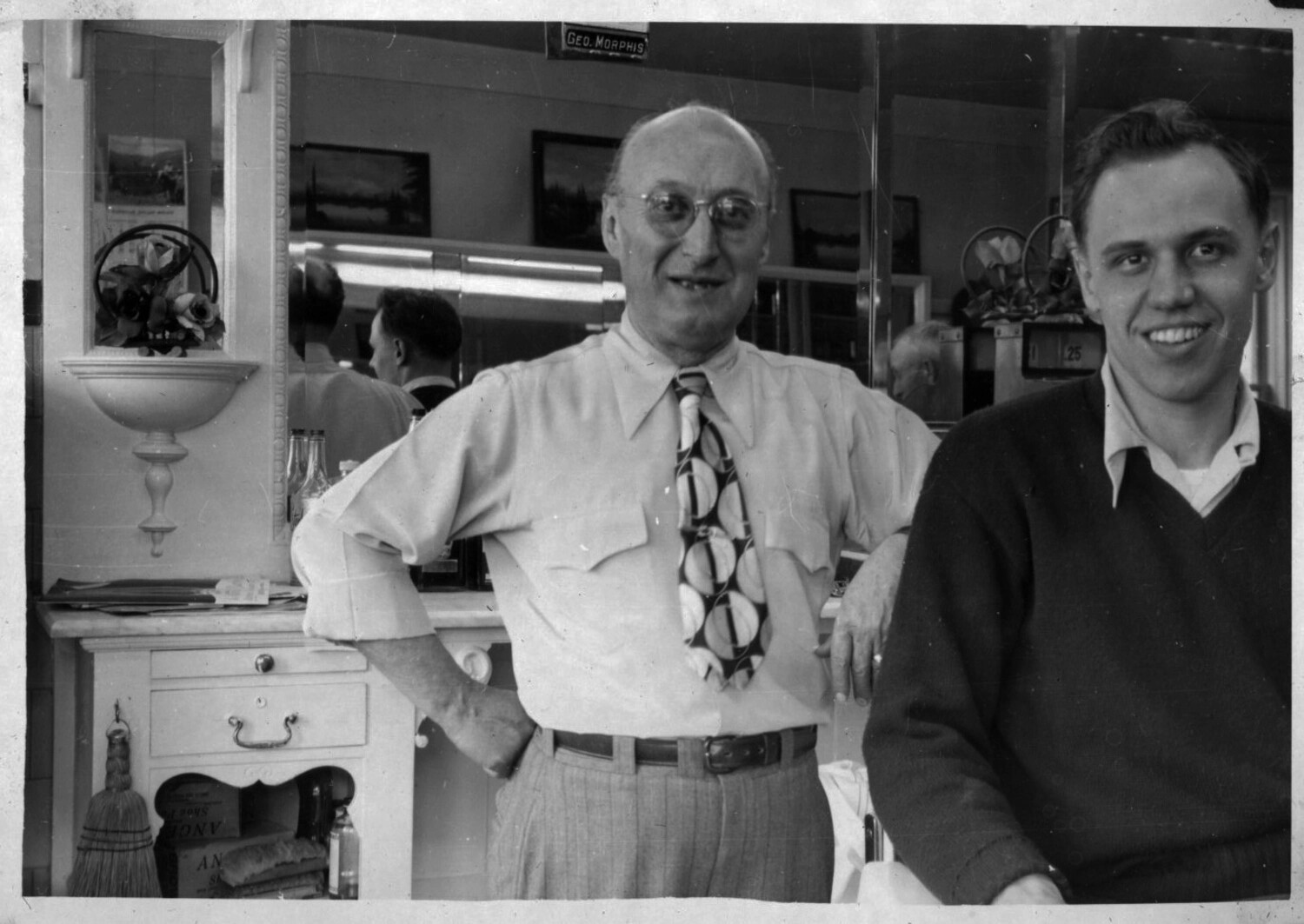 Two Men in Barbershop, 'Geo. Morphis' Signage — Bancroft Family Collection