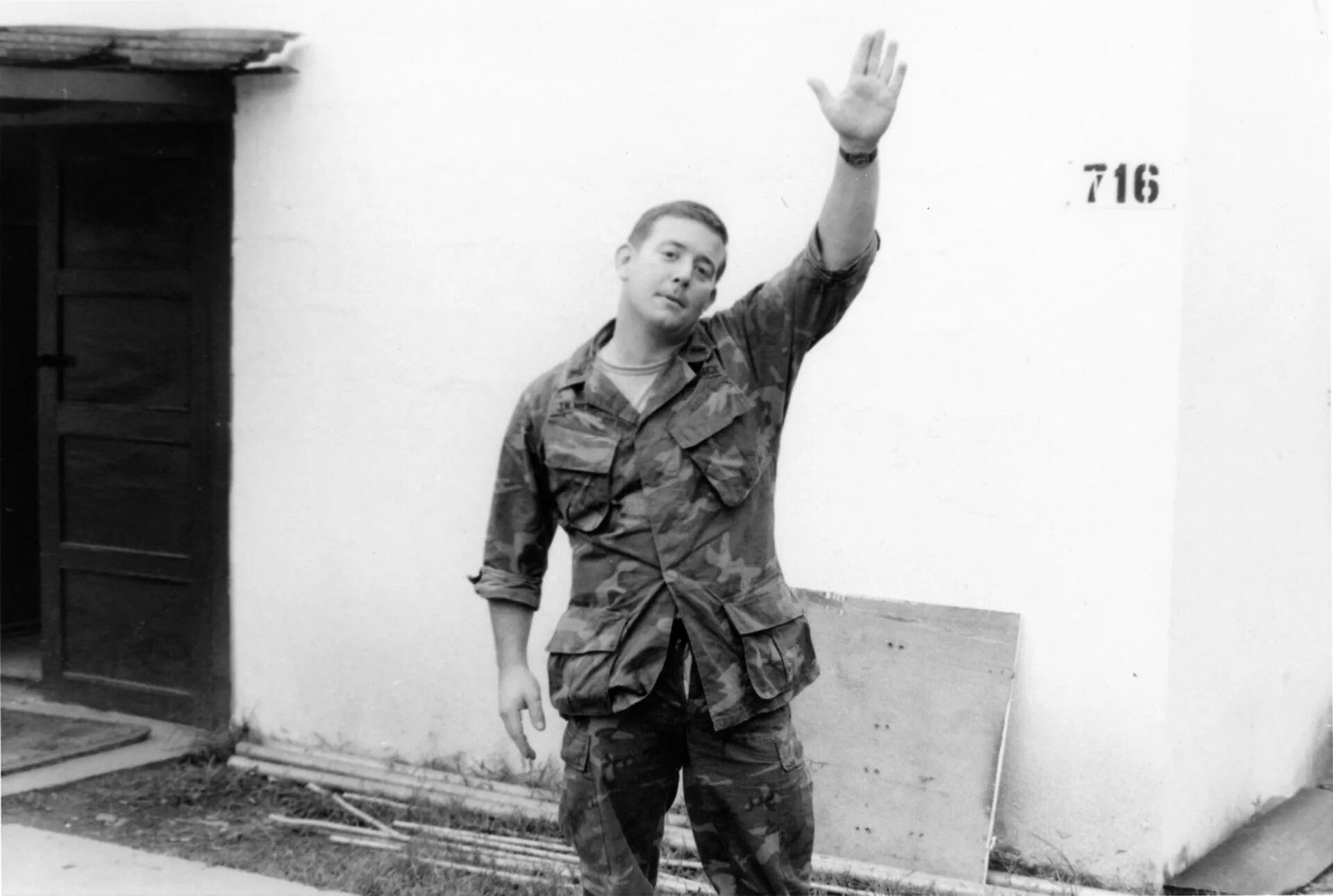 Serviceman Waving Outside Barracks Building 716, Southeast Asia, Vietnam War Era