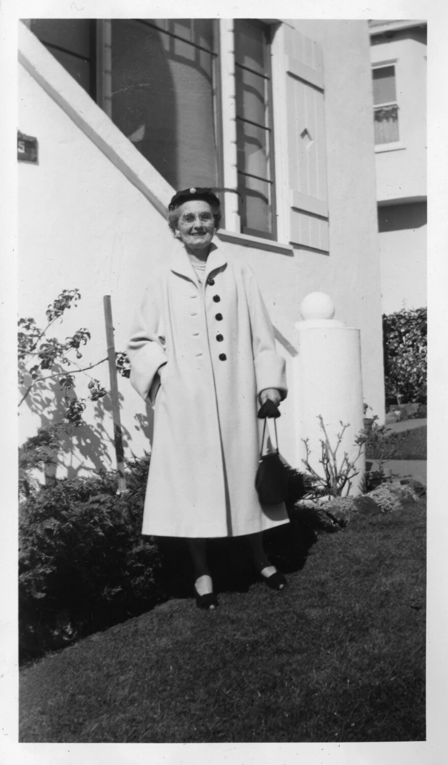 Elderly Woman in Wool Coat Outside a Stucco Residence, Presidio Album, c. 1950s