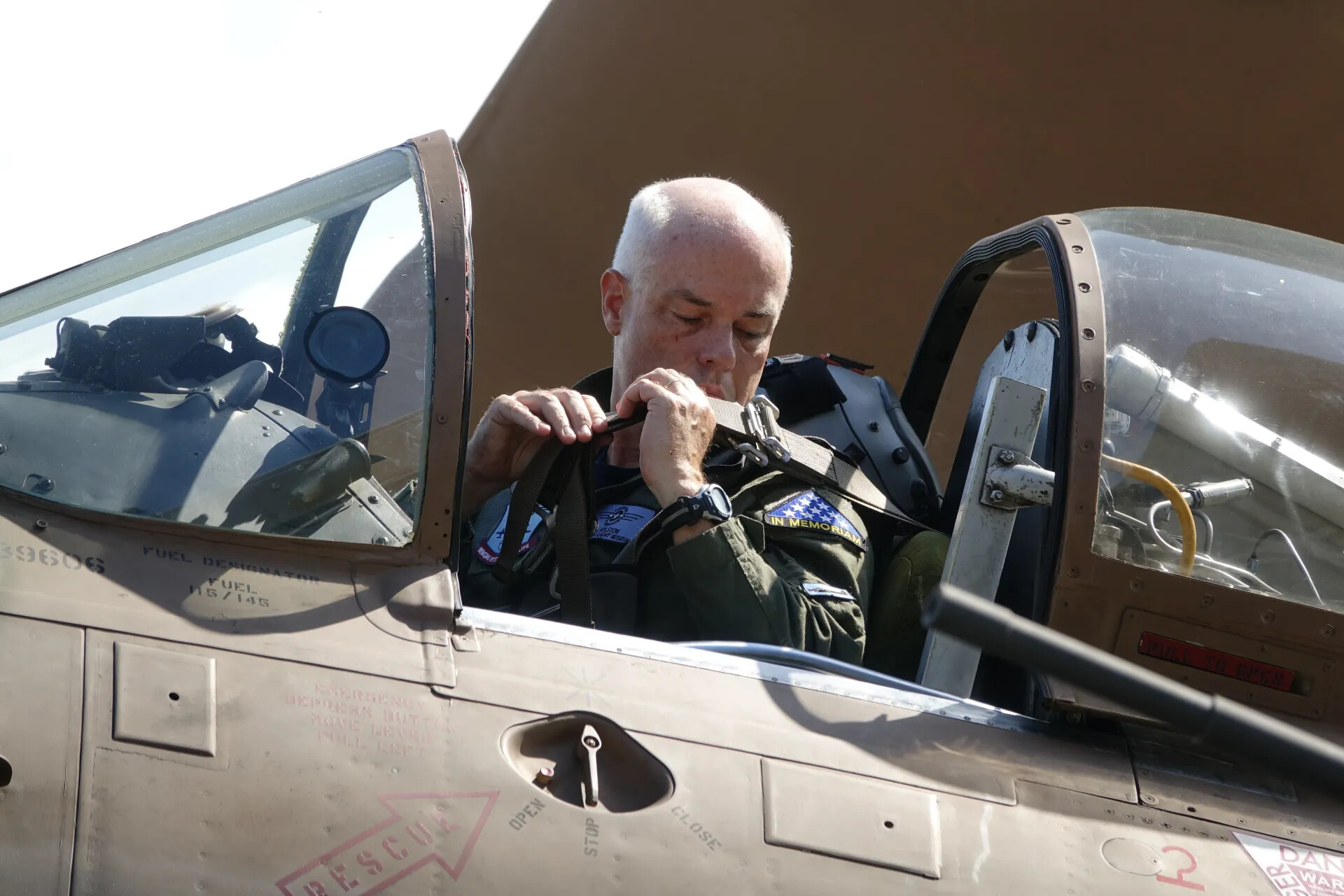 Pilot Preparing for Flight in A-1 Skyraider Cockpit, Wearing 'In Memoriam' Patch
