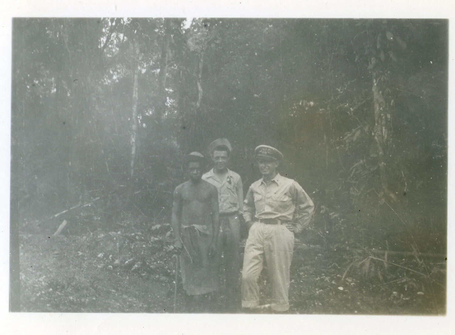 U.S. Officer, Serviceman, and Pacific Islander Man Posing Together in the Jungle, Southwest Pacific Area, World War II