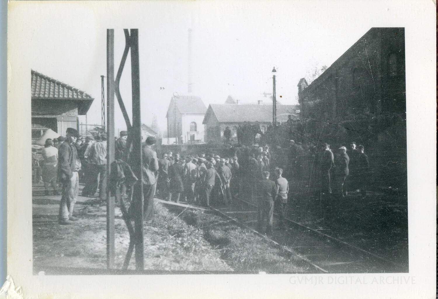 Column of Civilians Passing an Industrial Rail Yard under US Army Observation, 1945