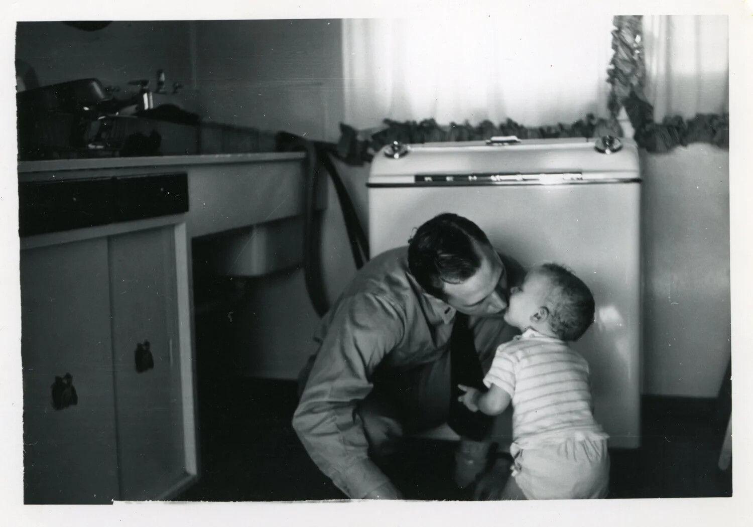 Serviceman Kissing Toddler in Home Kitchen, Korean War Era