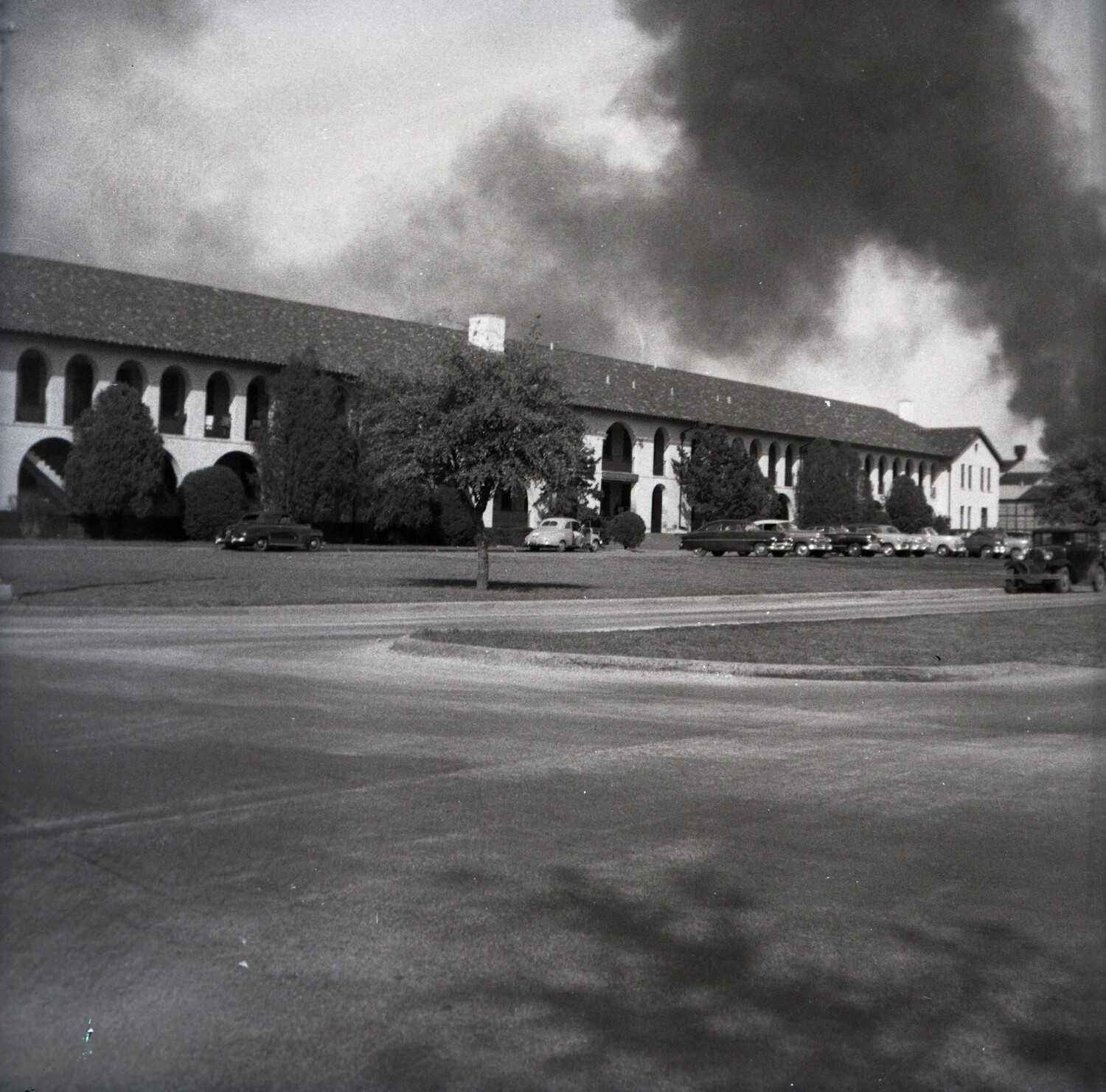 Black Smoke Rising Behind Spanish Colonial Revival Military Building