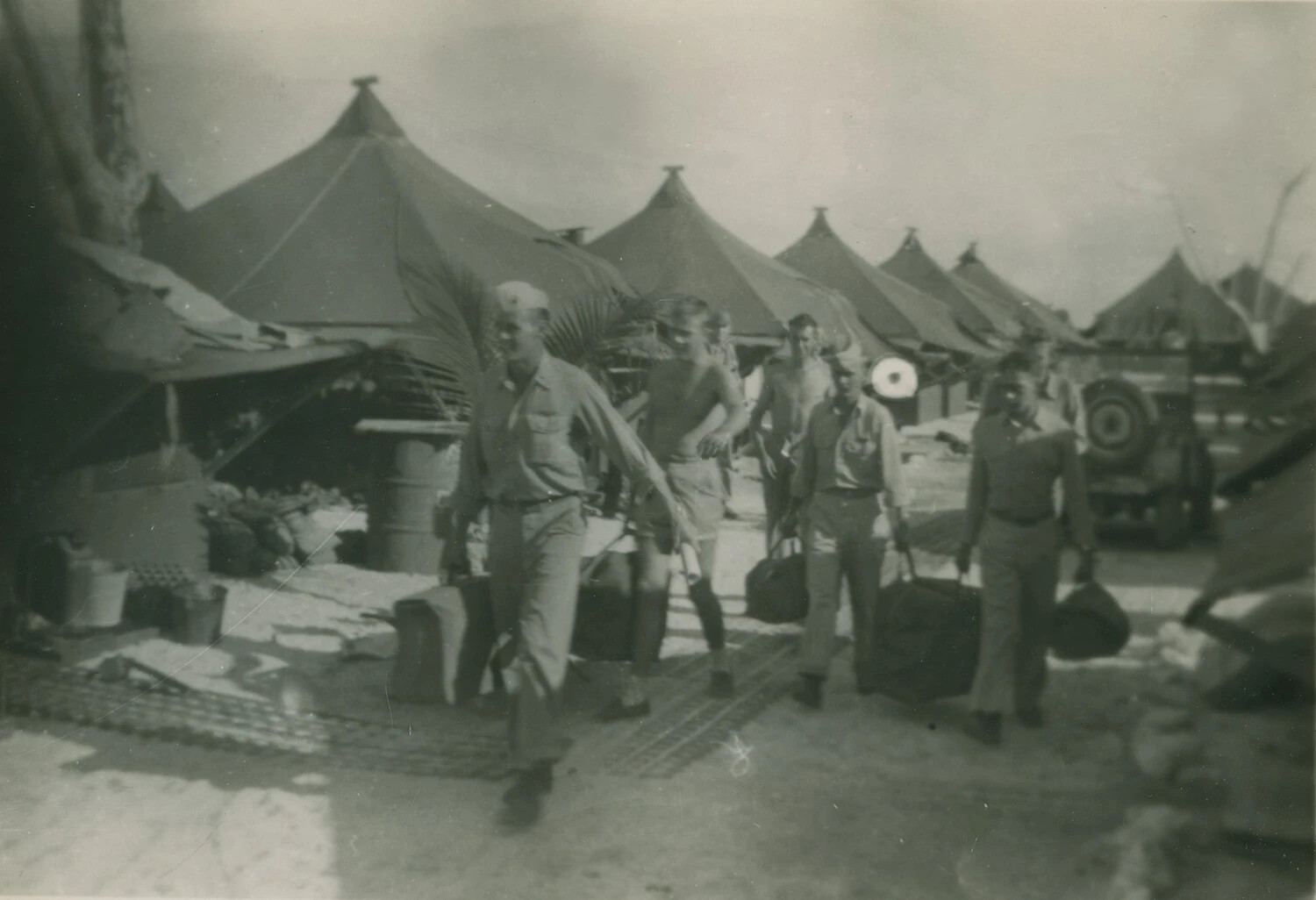 Servicemen Carrying Gear Through Tent Camp, Pacific Theater, WWII