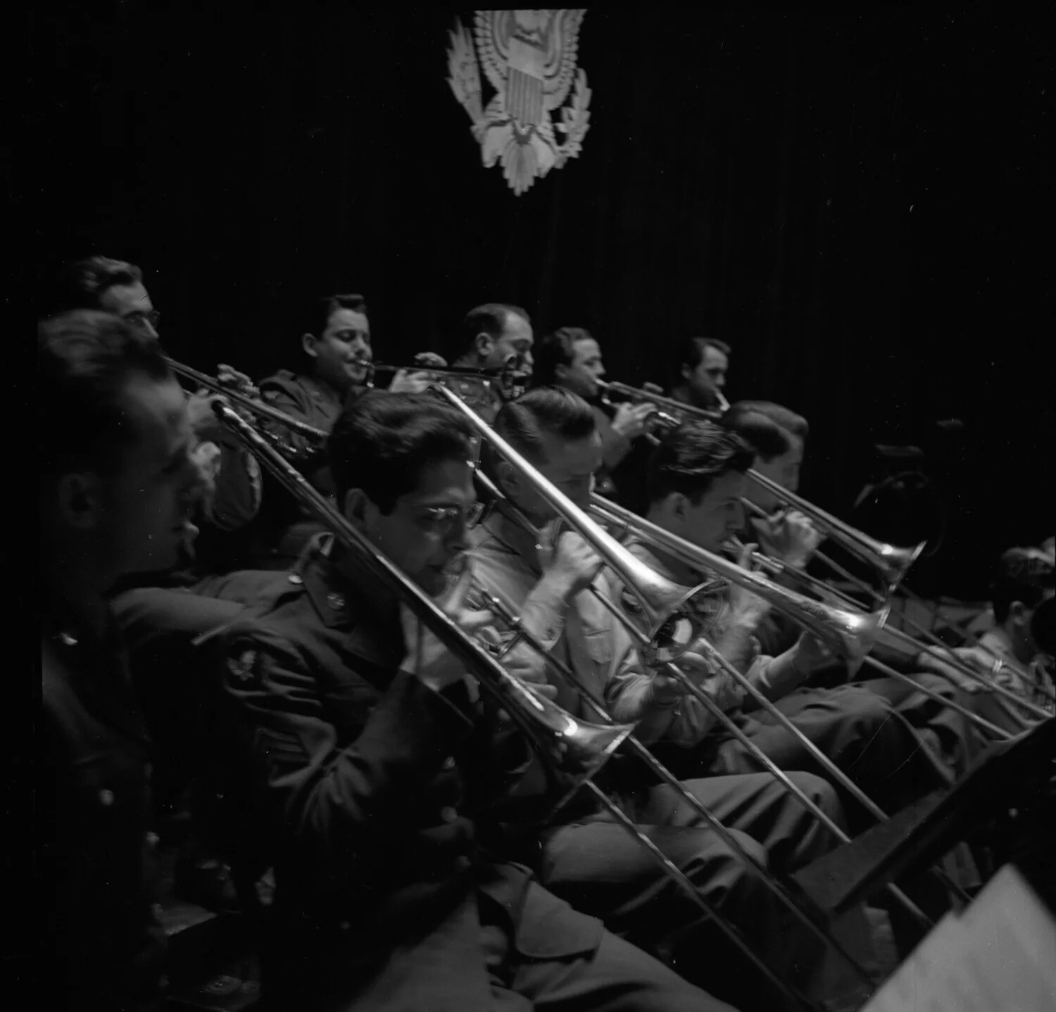 Trombone Section of a U.S. Military Band Performing Beneath the Great Seal of the United States