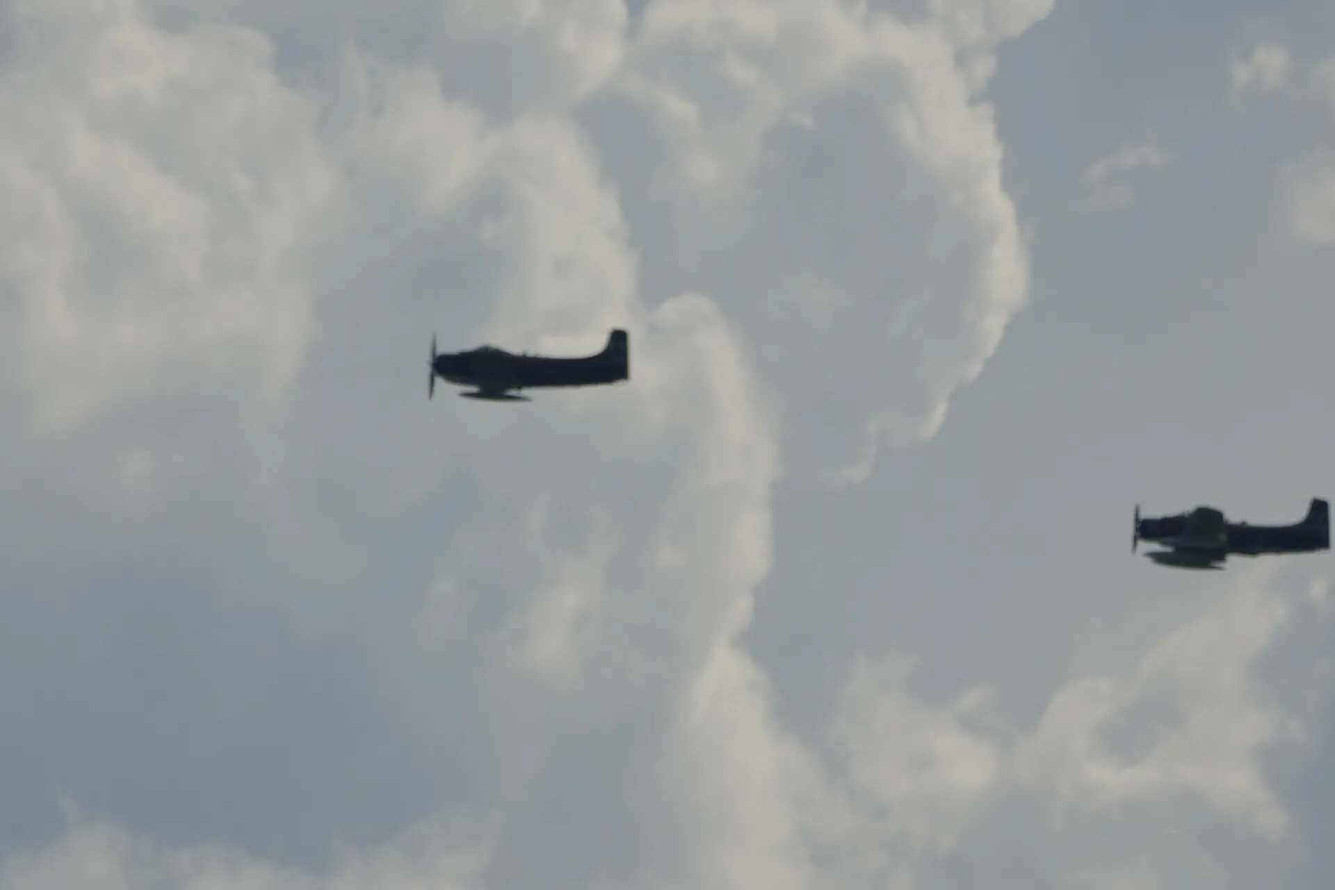 Two Douglas A-1 Skyraiders in Formation Flight, Backlit Against Clouds -- May 2019 Event, Don Engebretsen/Neal Melton Collection