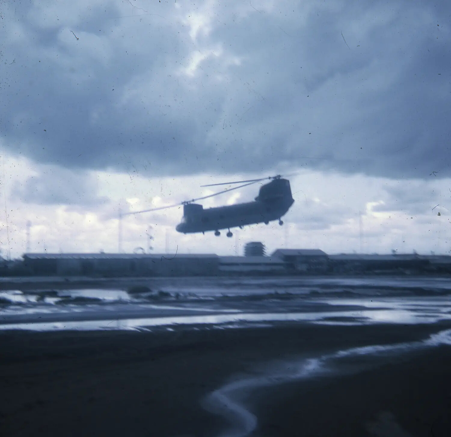 CH-47 Chinook Helicopter in Flight Over Vietnam Airfield, Storm Clouds