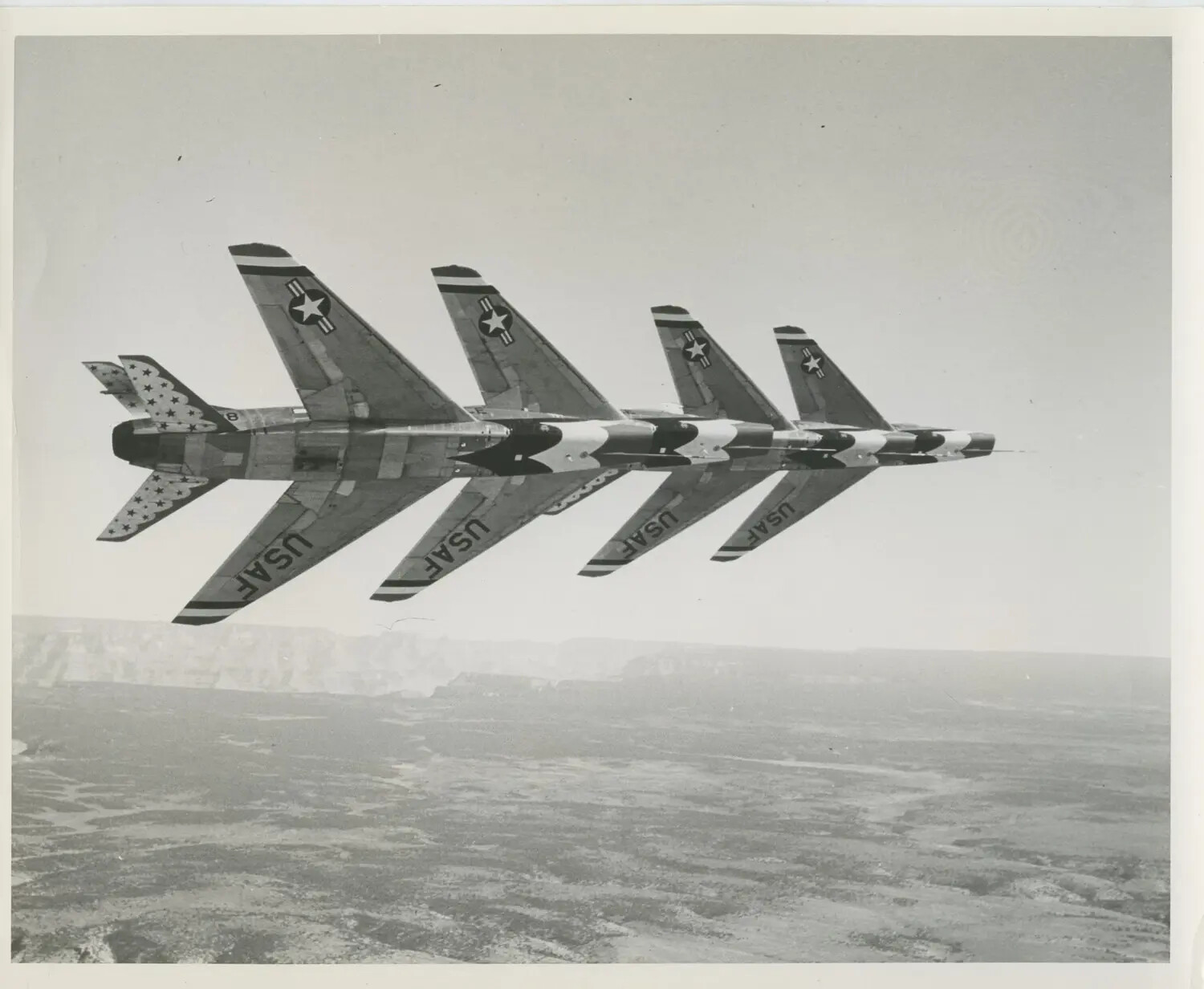 Thunderbirds F-100 Super Sabres in Tight Wingtip Formation Over Canyon Terrain