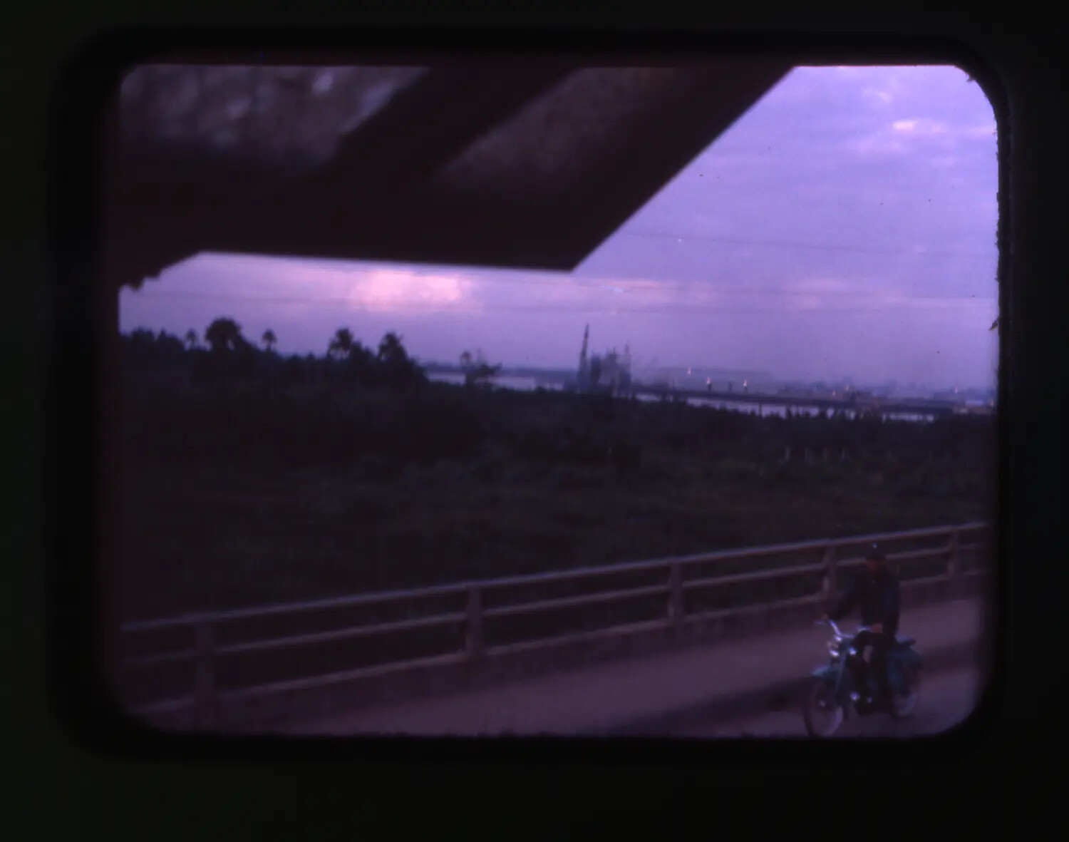 Vietnam War Era Color Slide: Twilight View of Bridge, Motorbike Rider, and Harbor Crane Silhouette, Vietnam