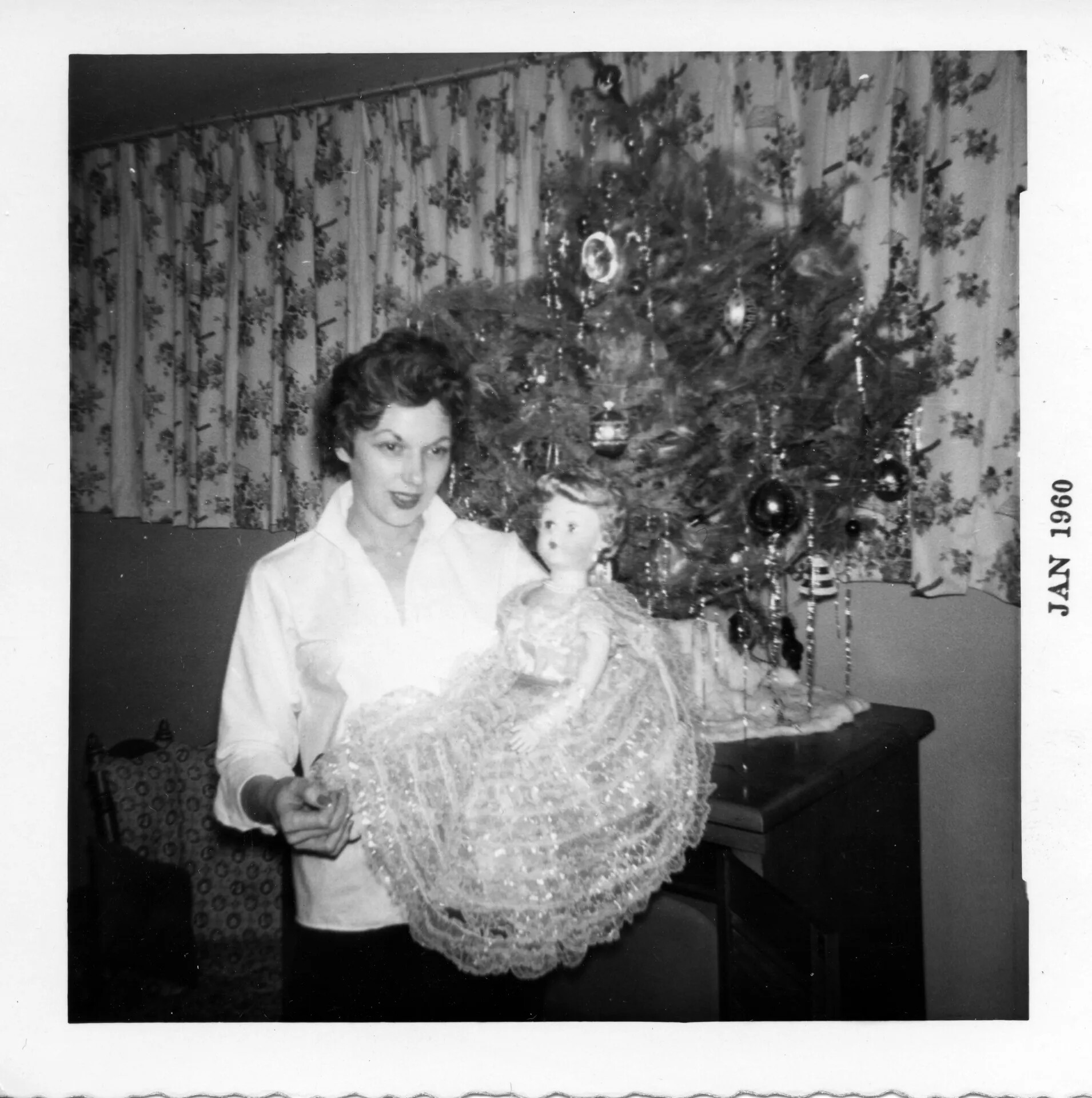 Woman Holding Doll in Front of Christmas Tree, January 1960