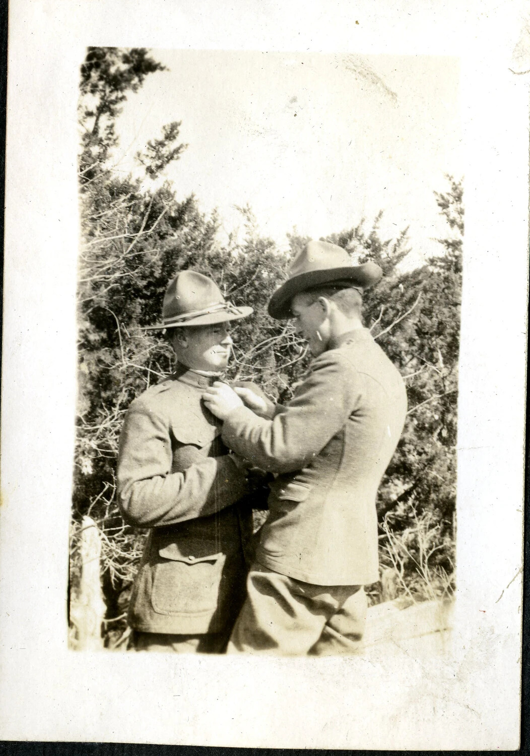 Two Soldiers with Campaign Hats, One Pinning Insignia on the Other, WWI-Era Training Camp, c. 1917-1918