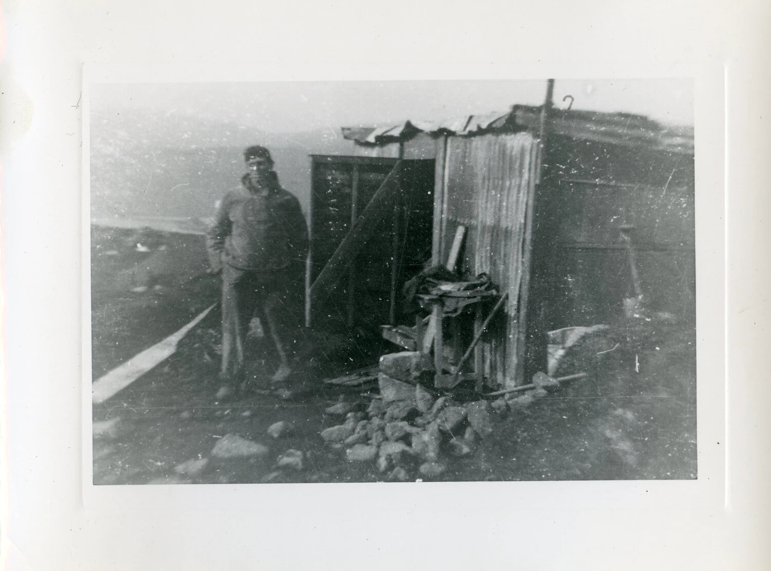 Serviceman Standing Beside Corrugated Metal Shelter, Aleutian Islands, World War II