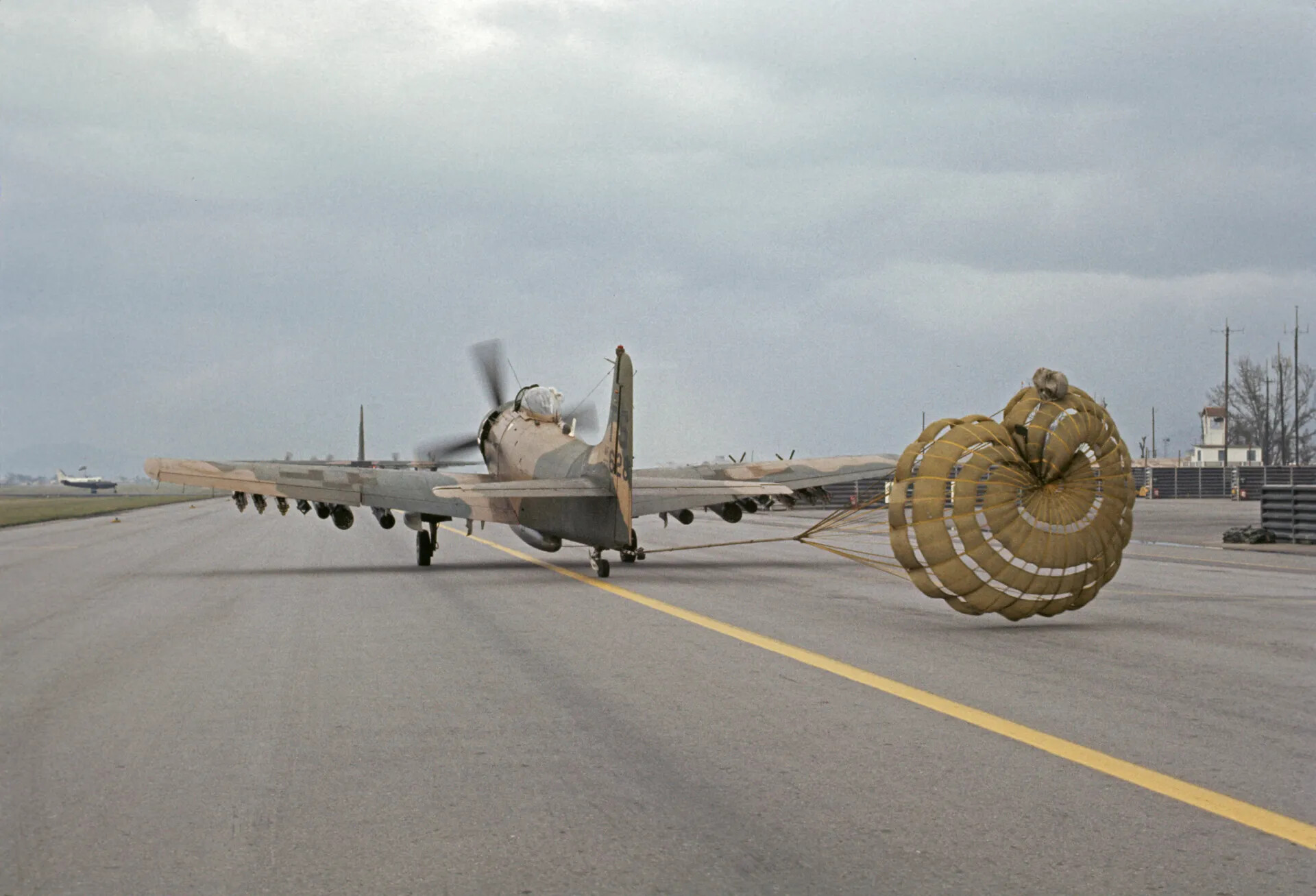 Camouflaged A-1 Skyraider Landing Rollout with Deployed Drag Chute
