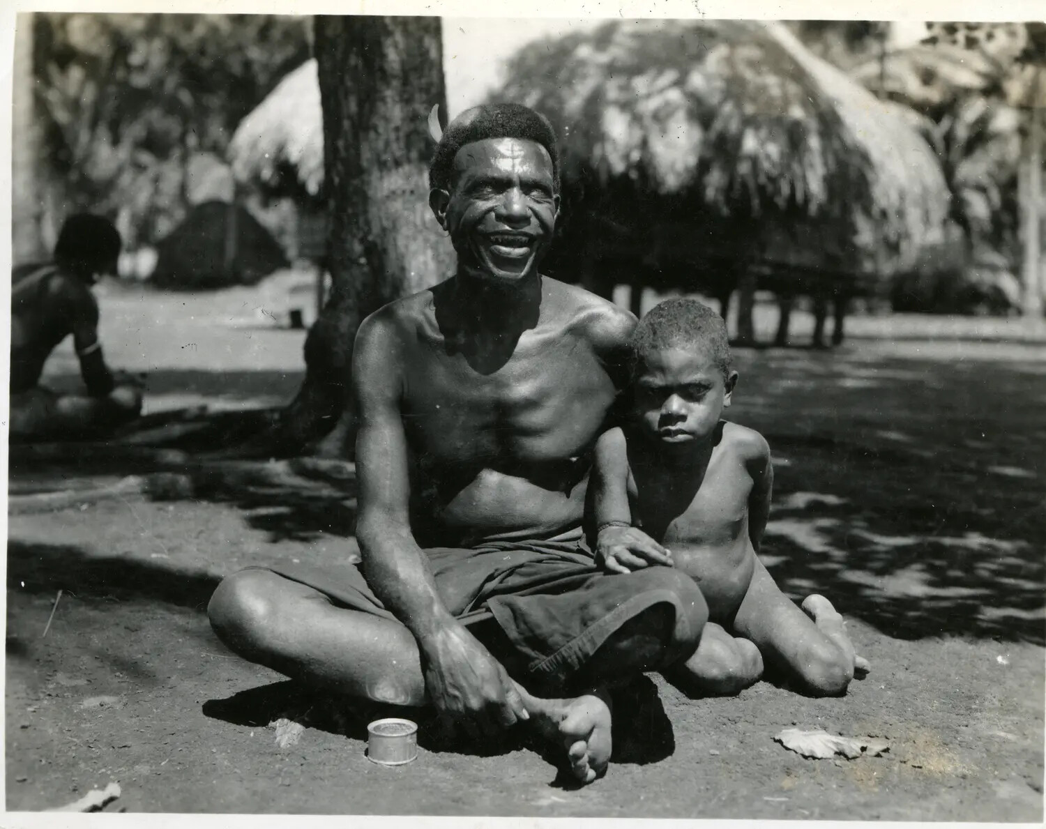 Local Man and Child Seated in Village, New Guinea, 312th Bombardment Group Collection, WWII