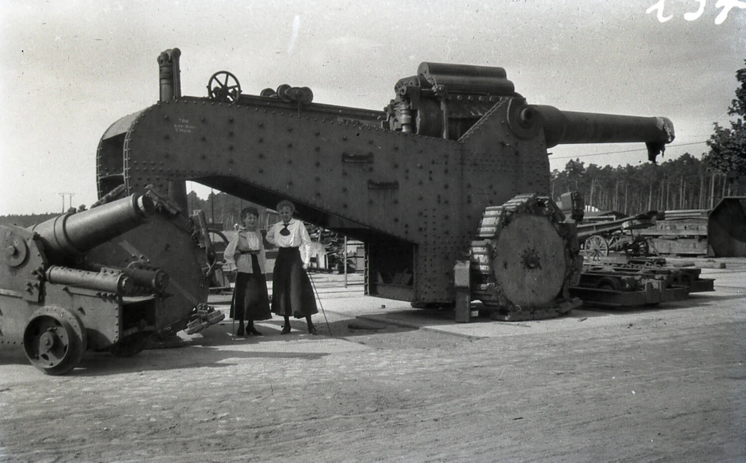 German WWI Heavy Siege Gun/Howitzer on Riveted Steel Carriage with Civilian Women for Scale, Ordnance Depot or Factory Yard
