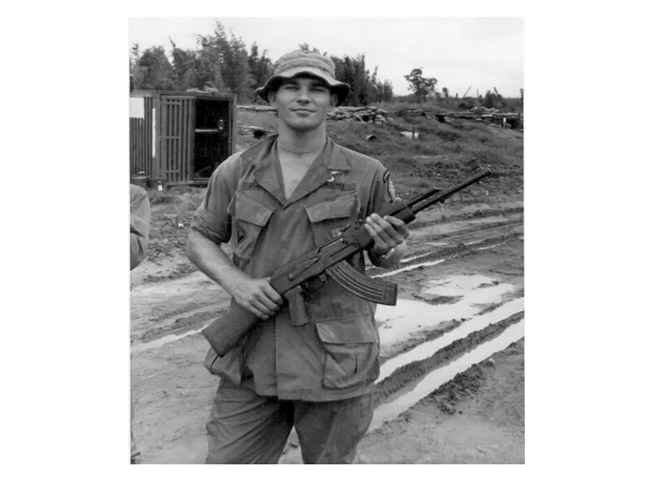 Serviceman with Captured AK-47 at a Vietnam-Era Forward Base
