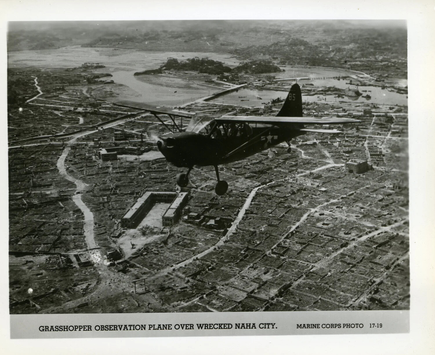 Grasshopper Observation Plane Over Wrecked Naha City, Okinawa -- Marine Corps Photo 17-19