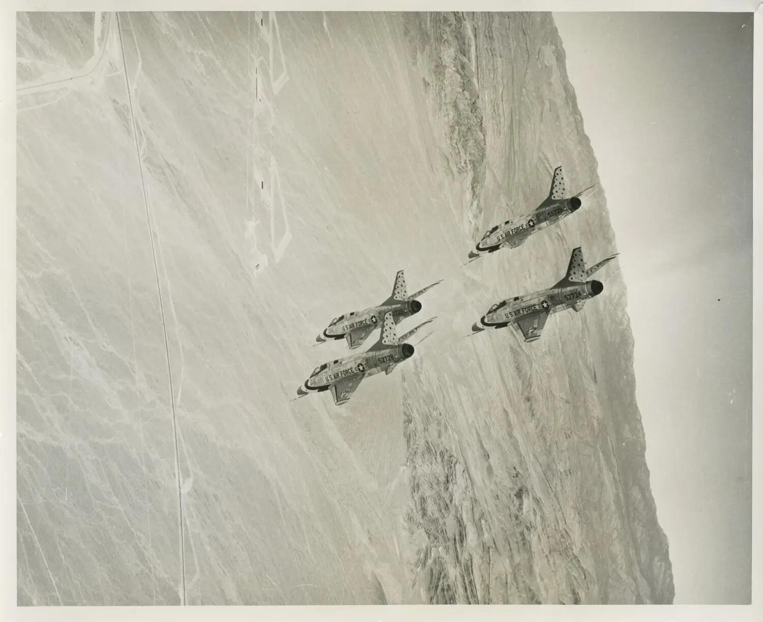 USAF Thunderbirds F-100 Super Sabres in Diamond Formation Over Desert Terrain