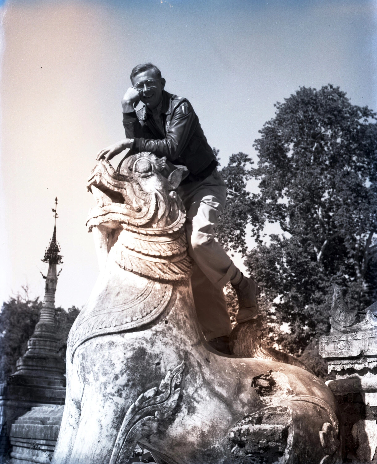 Airman Posing on a Chinthe Guardian Statue at a Burmese Pagoda, World War II