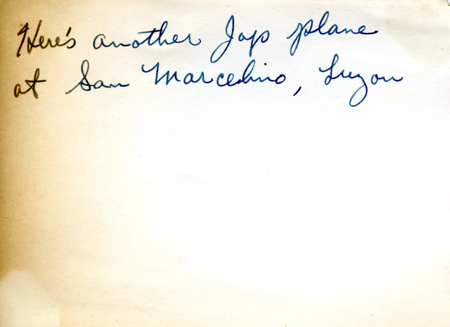 Handwritten Photo Album Caption: 'Another Jap Plane at San Marcelino, Luzon'