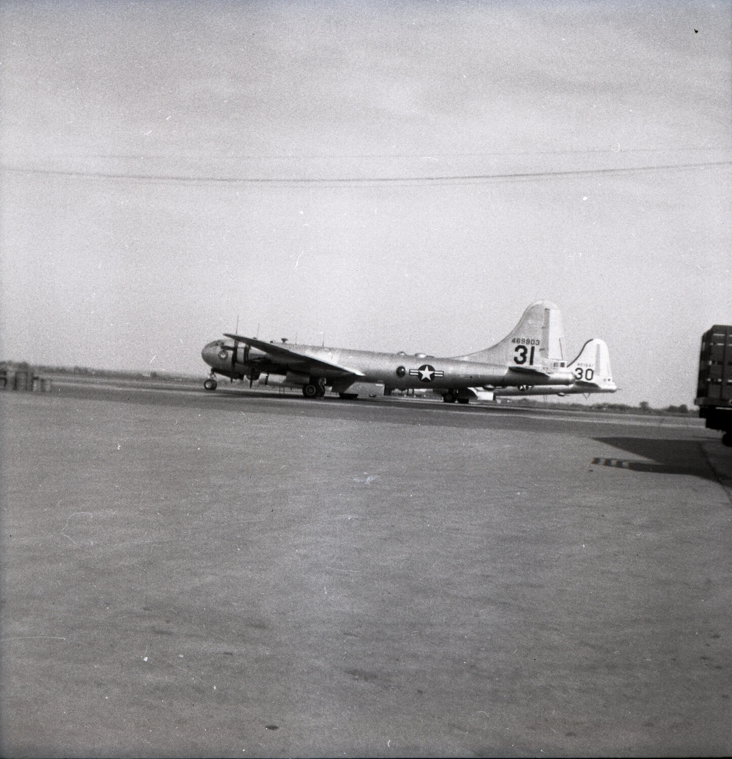 Two Boeing B-29 Superfortress Bombers, Tail Numbers 30 and 31, on Airfield Ramp
