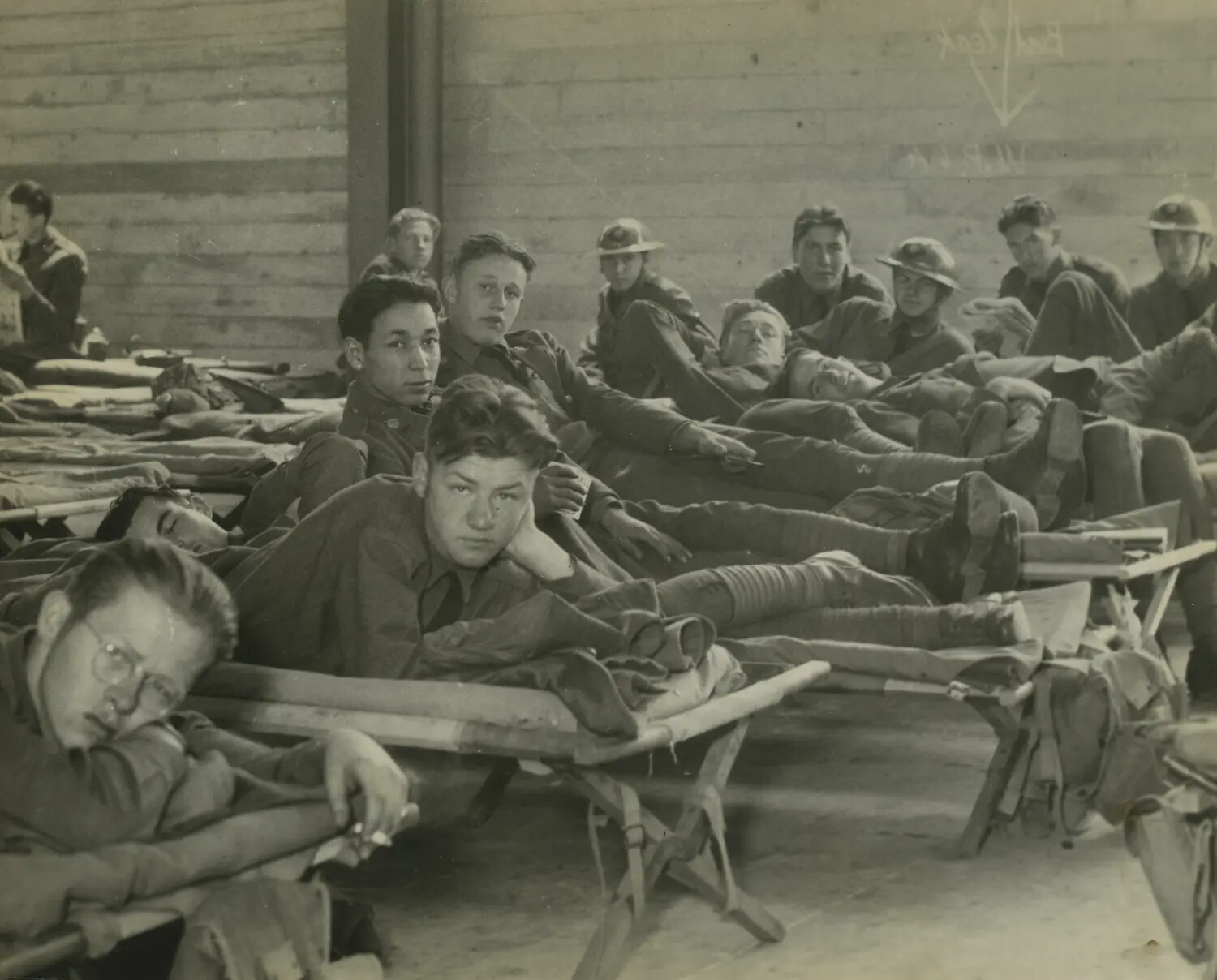 American Servicemen Resting on Cots in Improvised Barracks Quarters