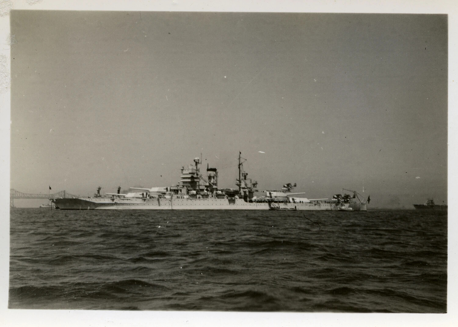 U.S. Navy Battleship or Heavy Cruiser at Anchor Near Bay Bridge, World War II Era
