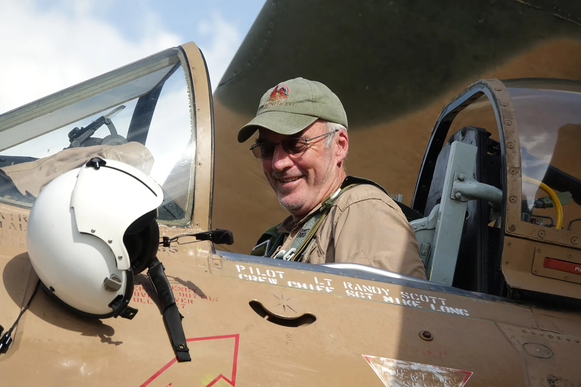 Man in Cockpit of Tan-Camouflage Warbird Trainer/Attack Aircraft, Marked 'Pilot Lt Randy Scott' — May 2019 Event