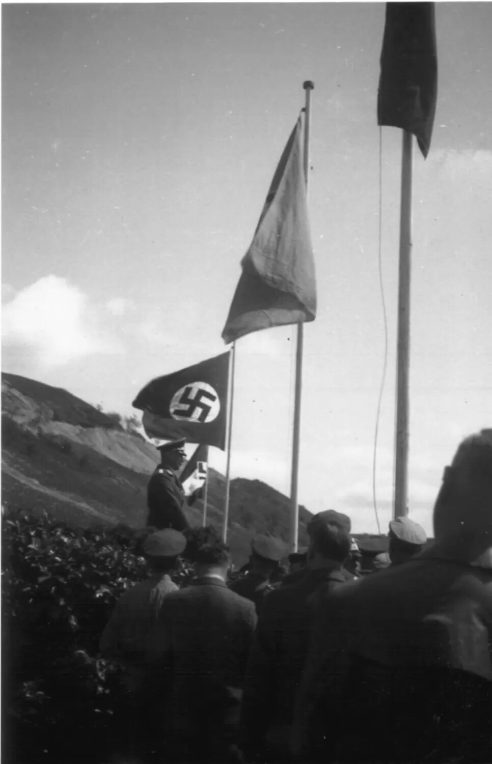 German Officer Addressing Assembly Beneath Swastika Flag, WWII Era