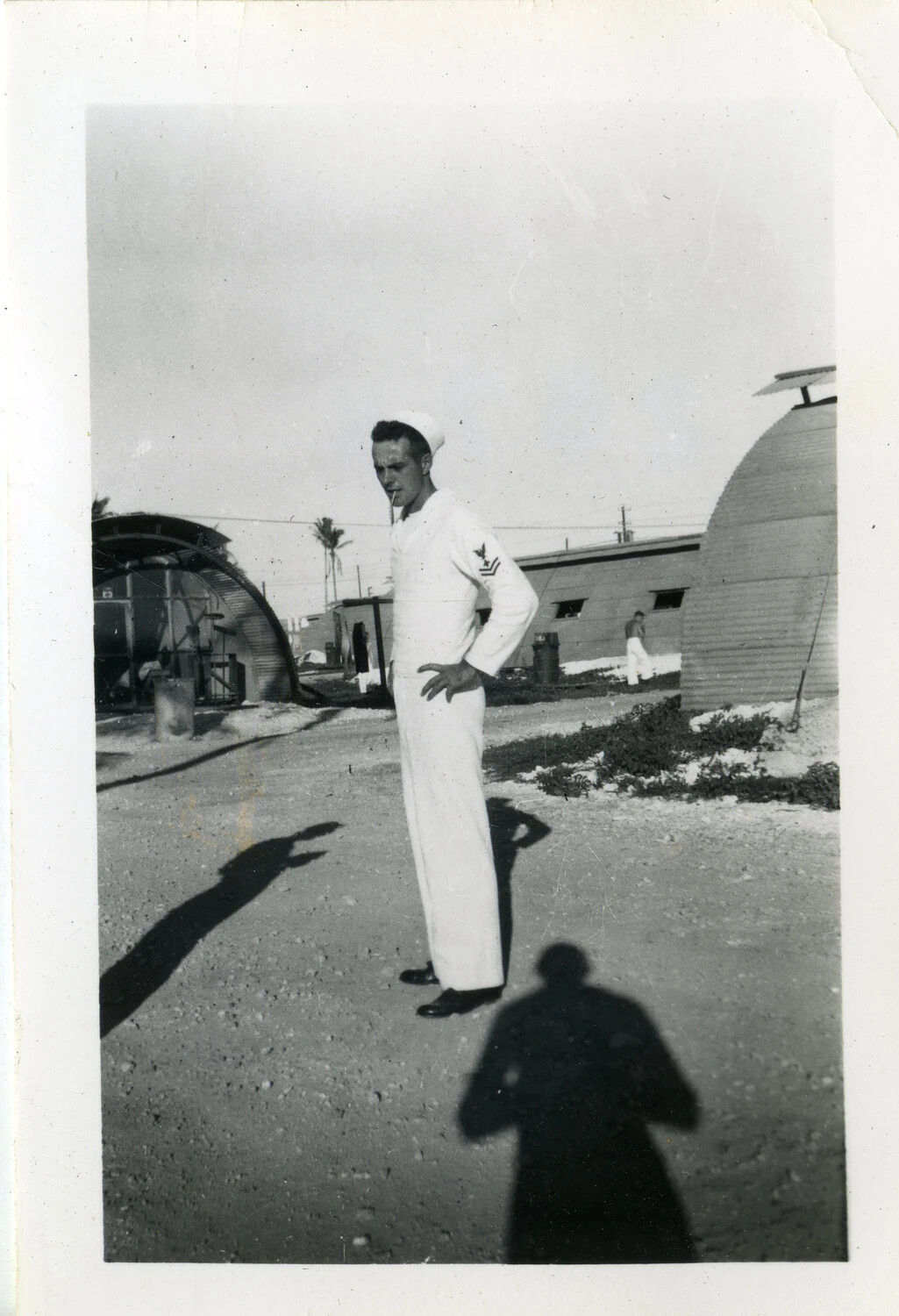 US Navy Sailor in Dress Whites at Quonset Hut Encampment, Likely NAS Agana, Guam