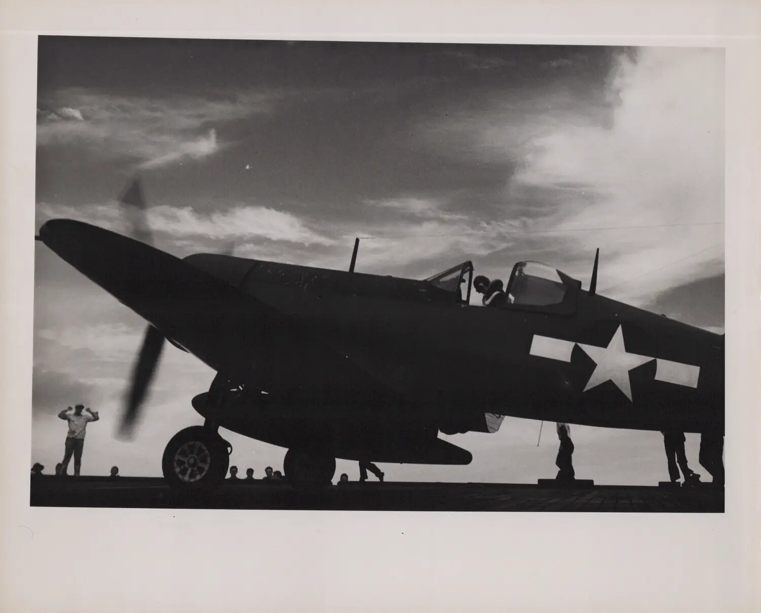 Silhouetted FM-2 Wildcat Fighter on Escort Carrier Flight Deck, WWII Pacific Theater