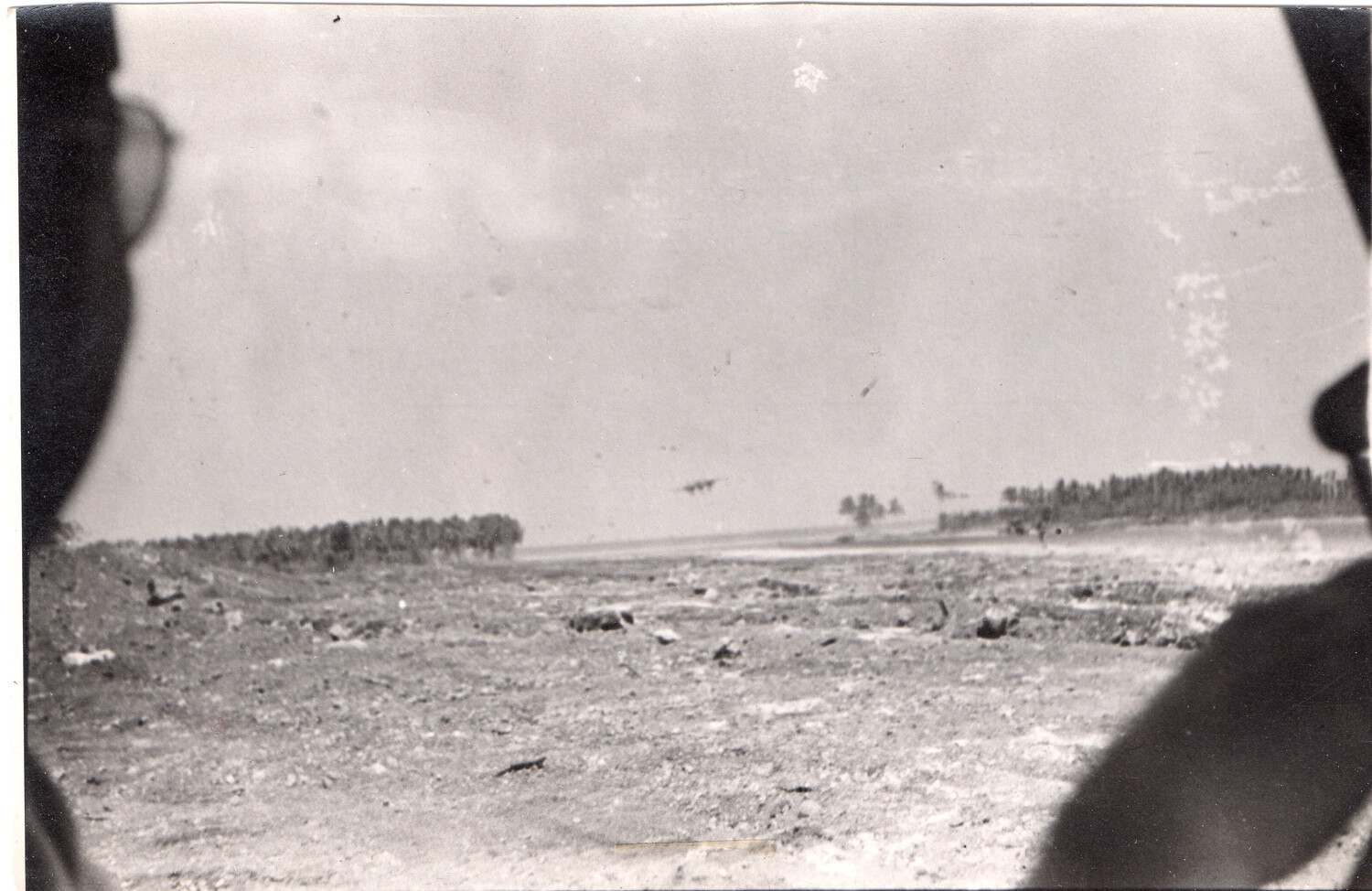 Candid Snapshot of an Open Airfield or Cleared Terrain with Distant Aircraft, Pacific Theater, WWII Era