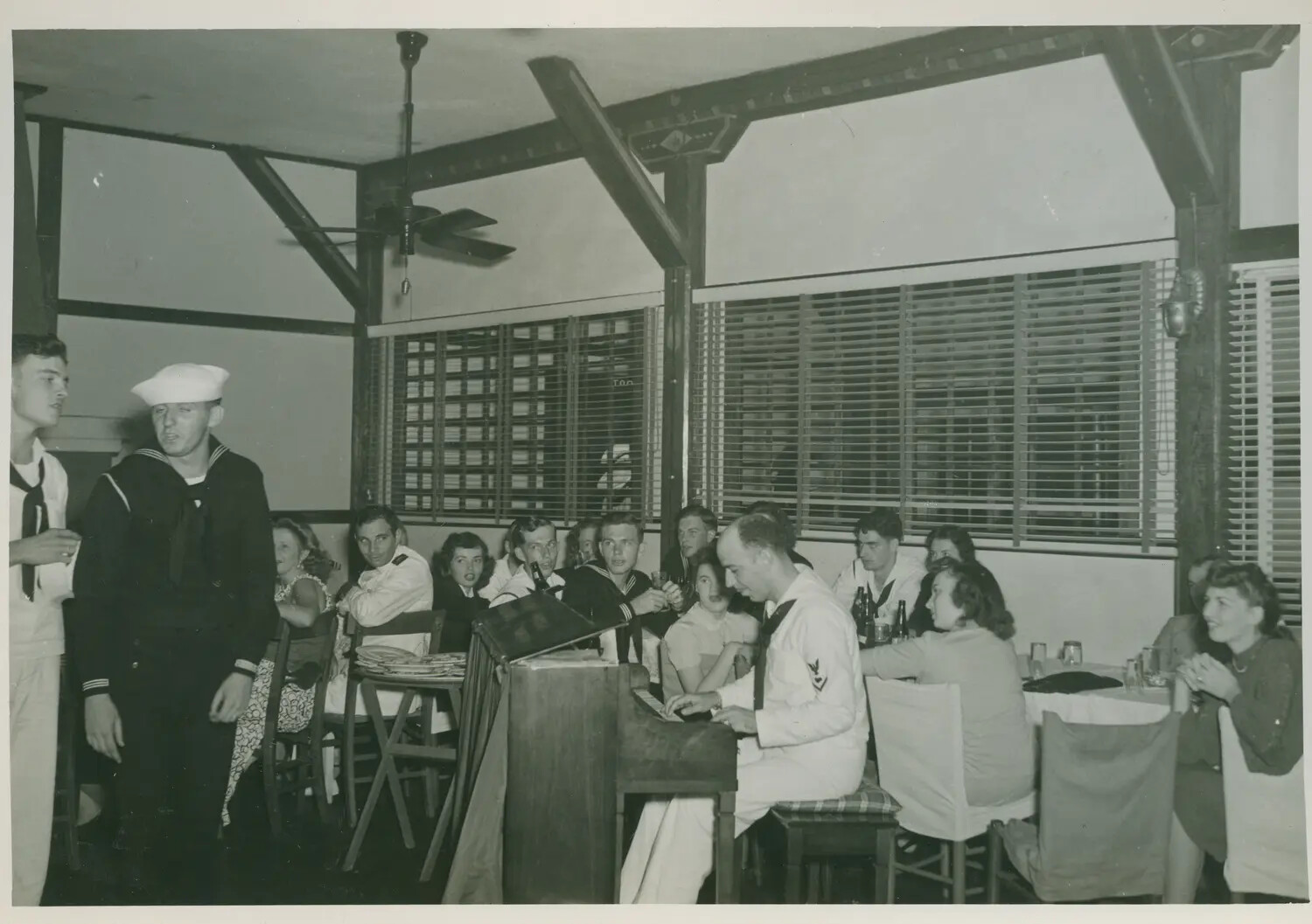 Navy Sailors and Guests at a Wartime Social Gathering with Piano Sing-Along, USS Petrof Bay (CVE-80) Collection, WWII