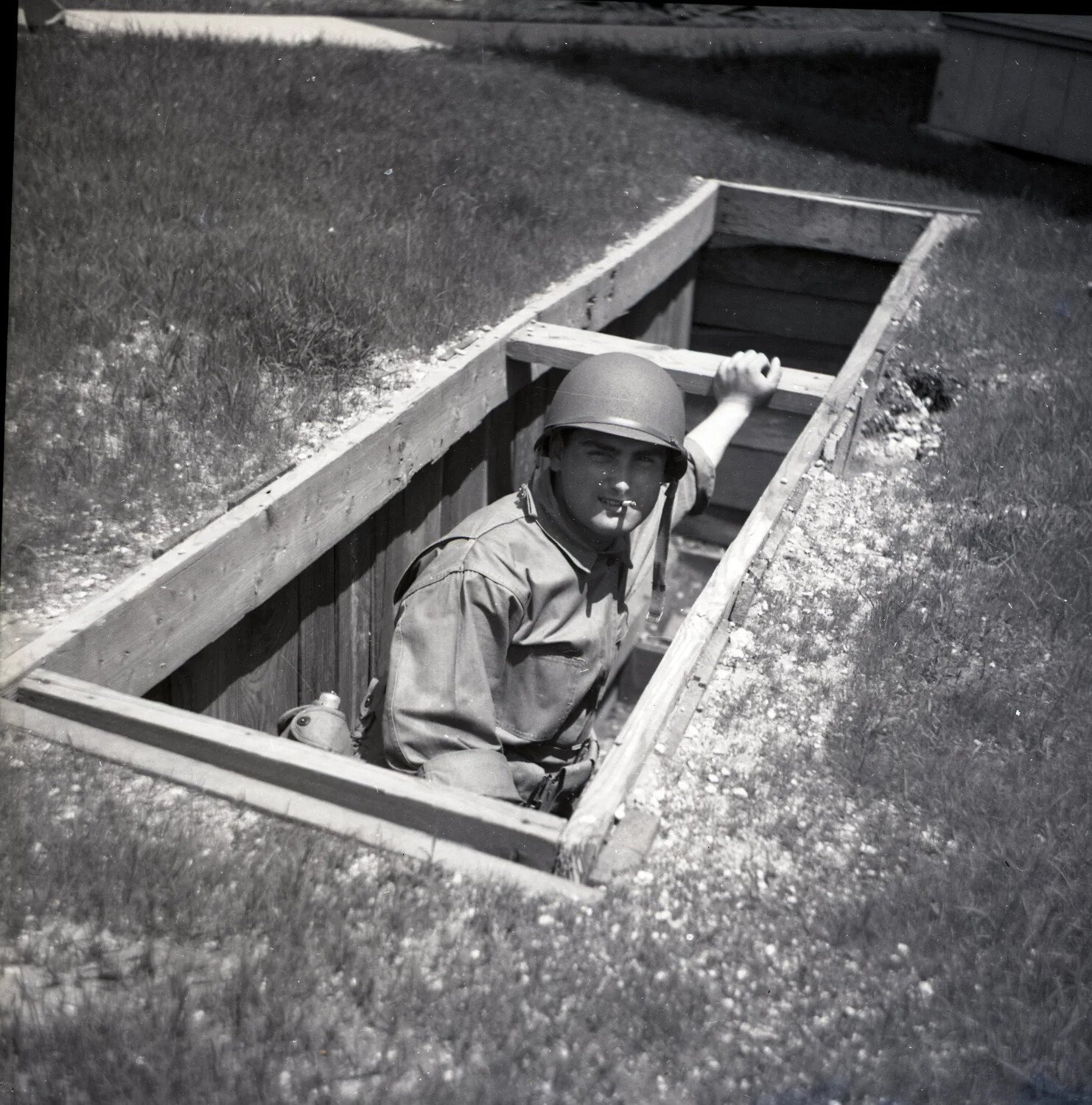 Soldier in Wood-Reinforced Foxhole During Field Training, WWII Era