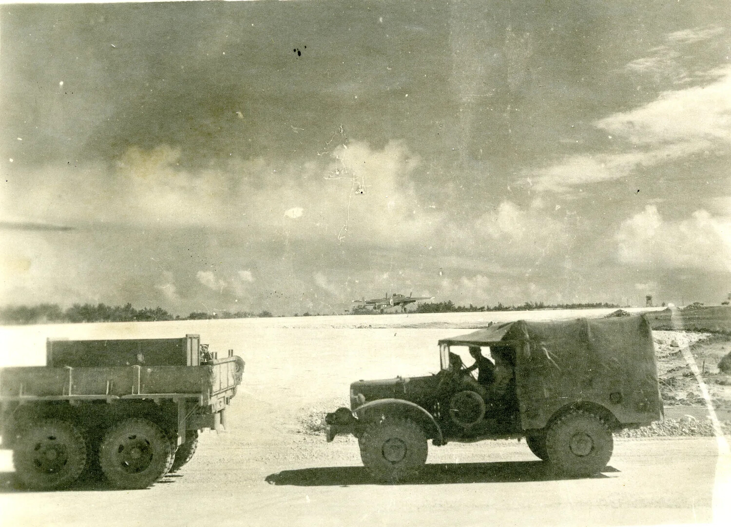 U.S. Army Cargo Trucks on Airfield Access Road with B-25 Mitchell in Background, Ie Shima, 1945