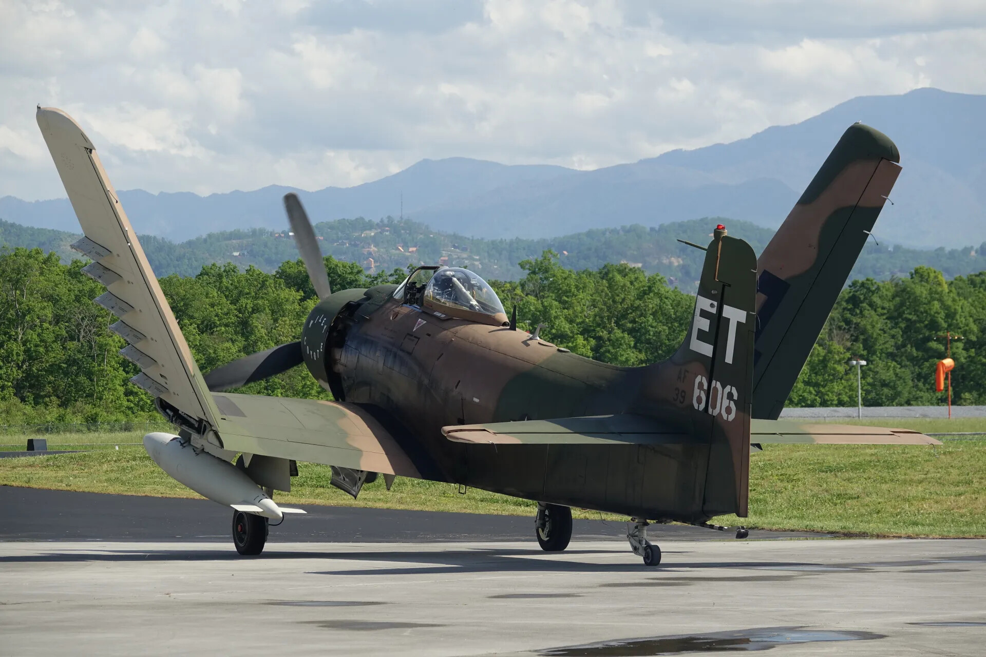 A-1 Skyraider 'ET 606' on Ramp, Wings Folded, Mountain Backdrop