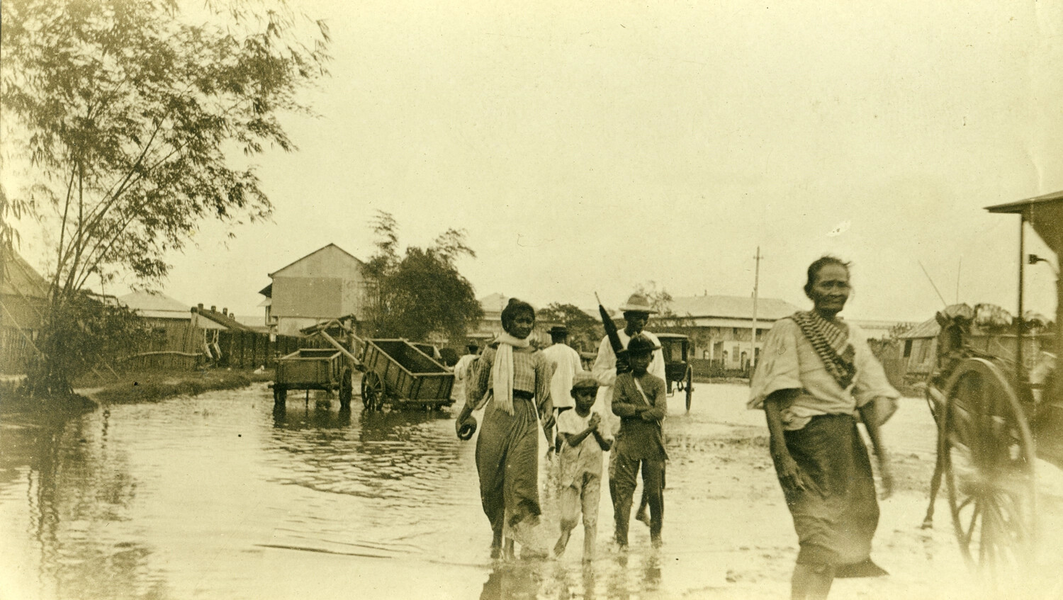 Flooded Street Scene with Armed Local Man and Civilians, Philippines, Early 1900s (Carl Stone Collection)