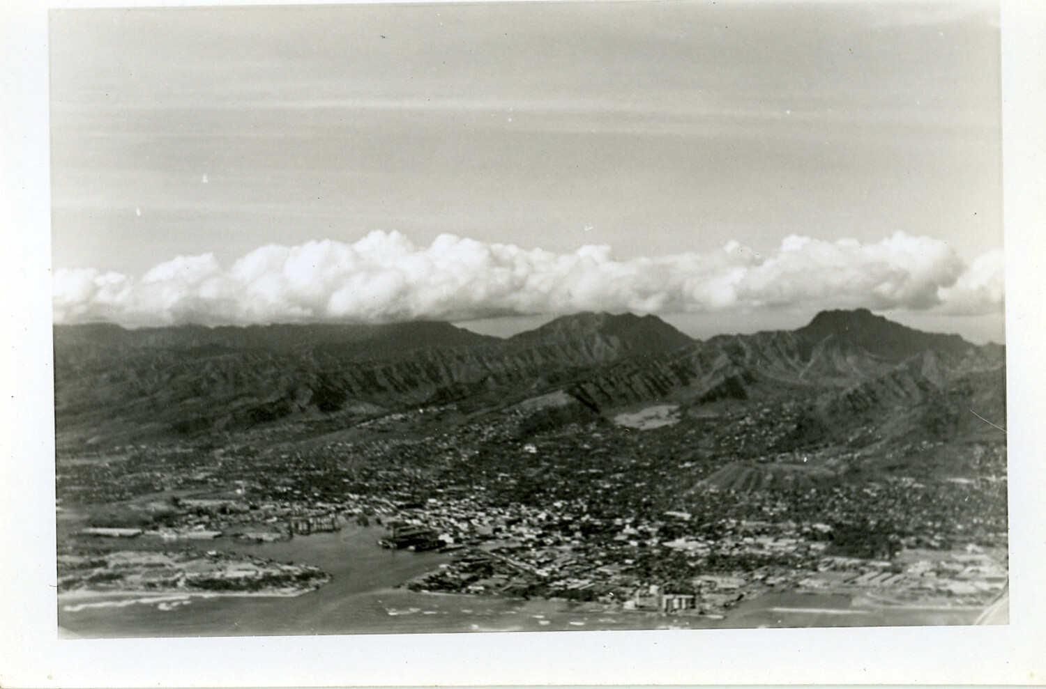 Oblique Aerial View of Windward Mountain Range and Coastal Settlement, Likely Oahu, Hawaii, WWII Era