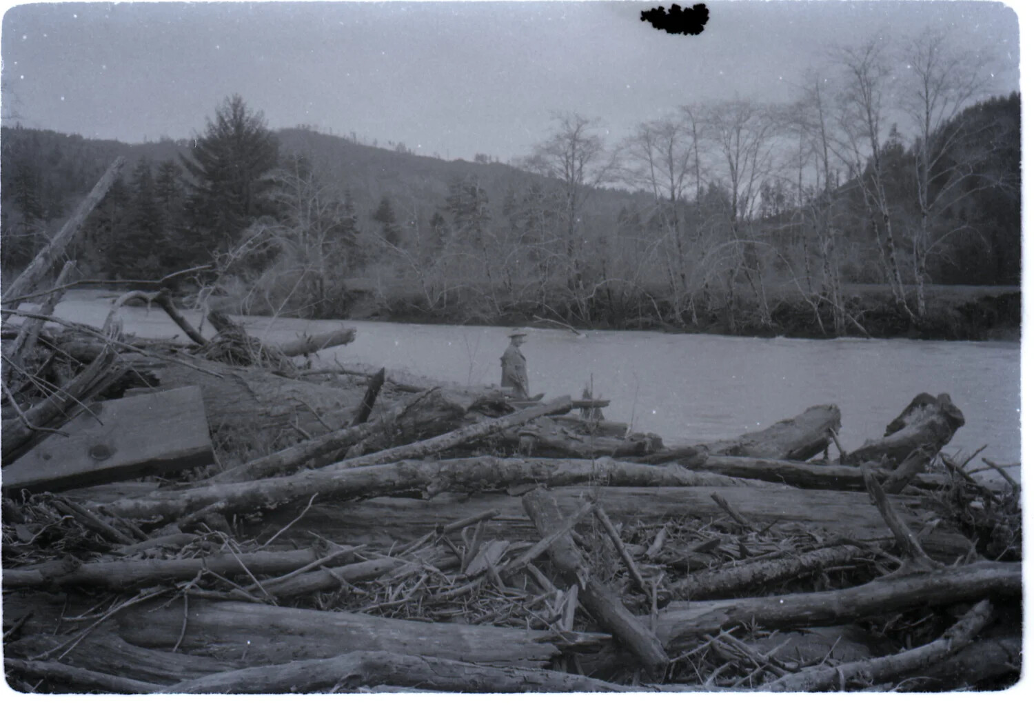 Man Standing Beside a Driftwood-Strewn Riverbank, 'Ranch,' 1958 (Personal Photograph, USS Yorktown Slide Collection)